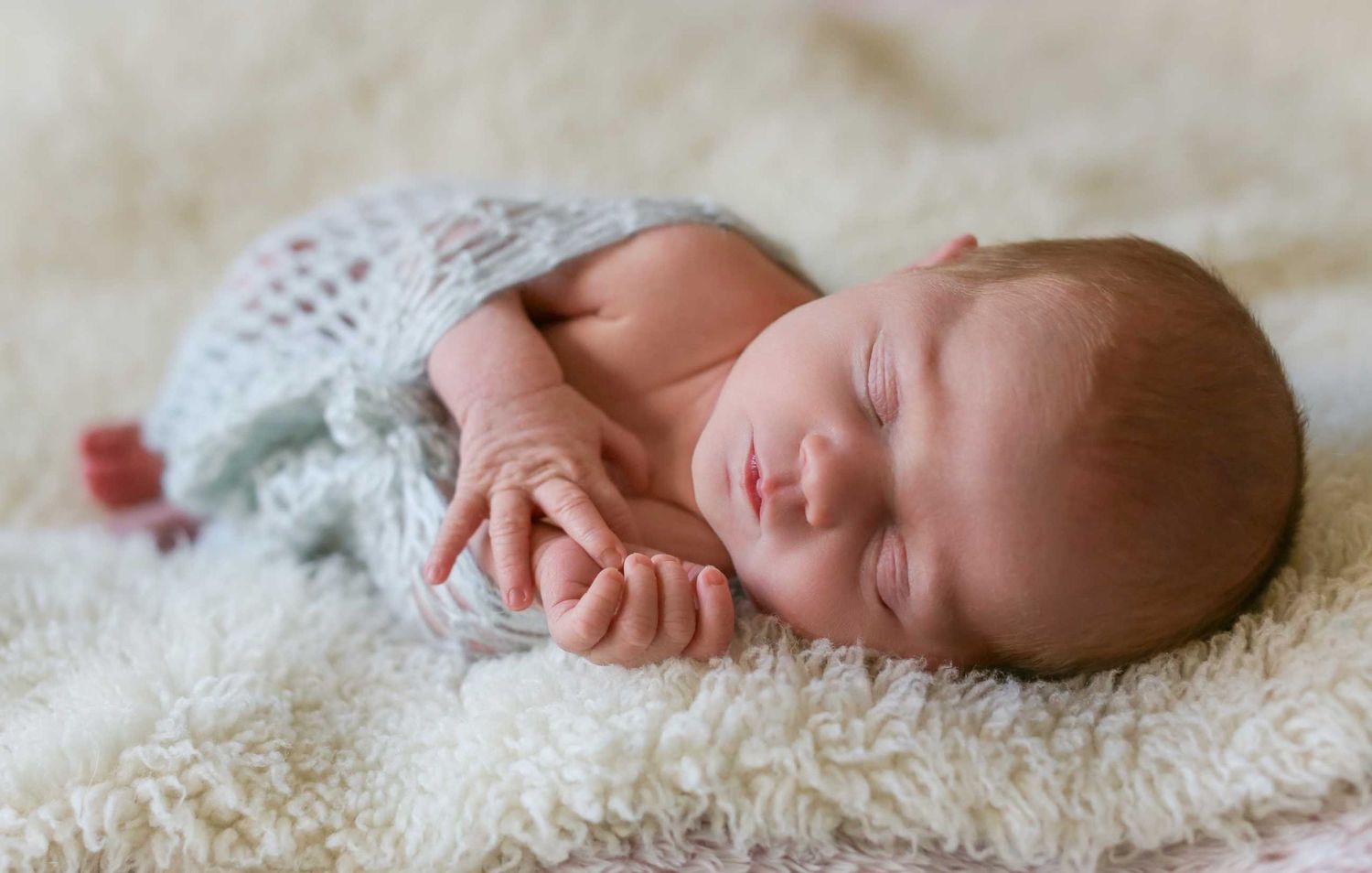 A series of newborn baby photos showing different sleeping poses on soft white textured fabric.