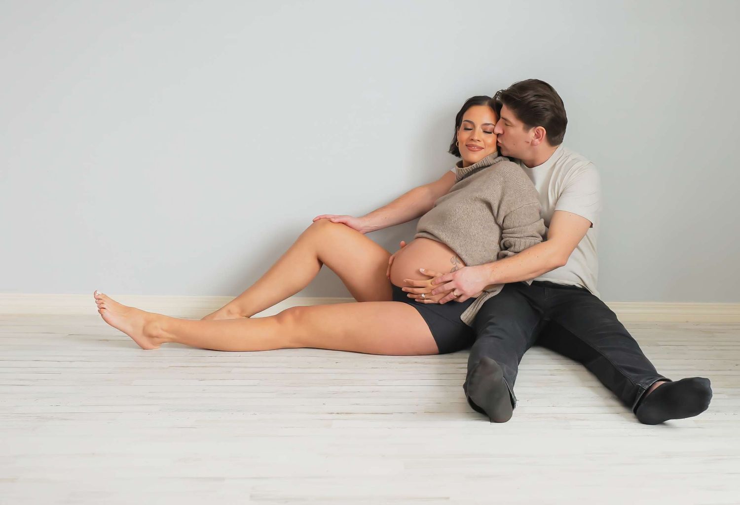 Two people in casual clothing lying close together on a light colored floor. Redmond Oregon Studio