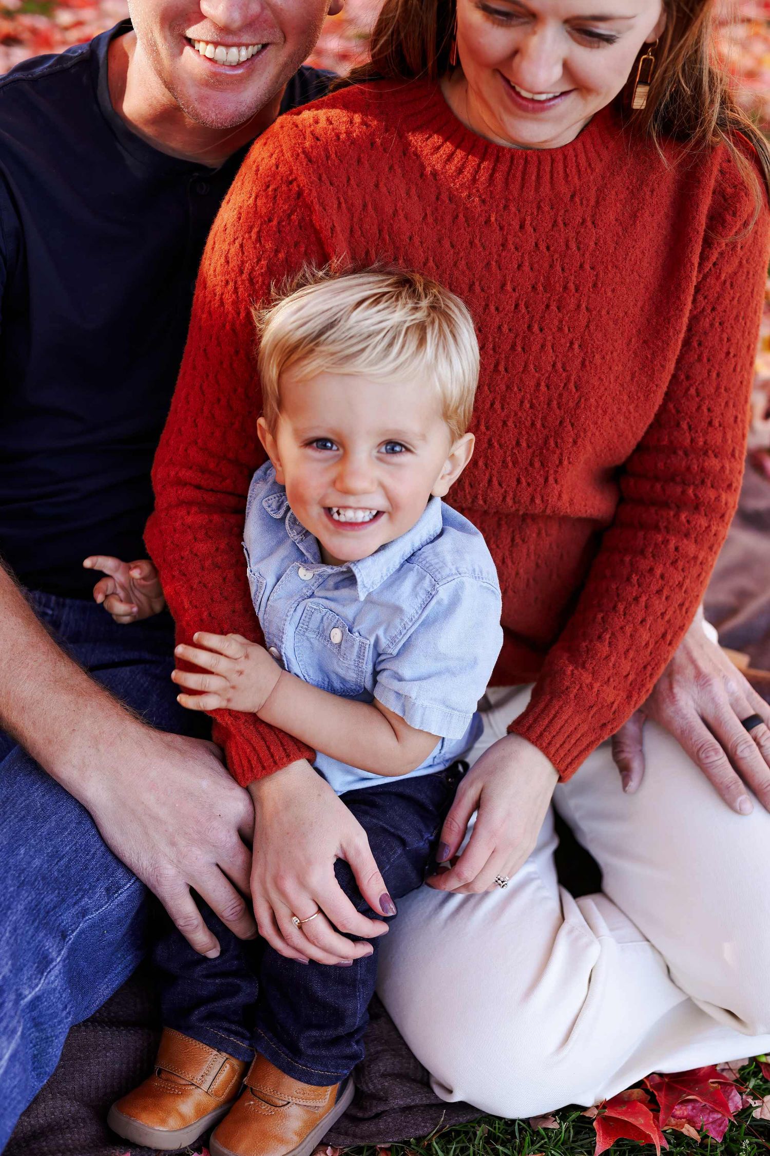 Family photo series showing candid moments between parents and young child wearing blue shirt and red sweater.
