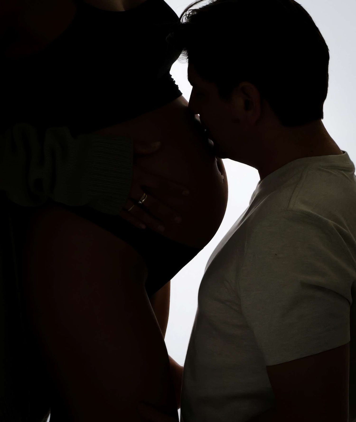 Silhouette of a couple sharing a romantic kiss in soft backlit lighting. Redmond Oregon Studio Photoshoot