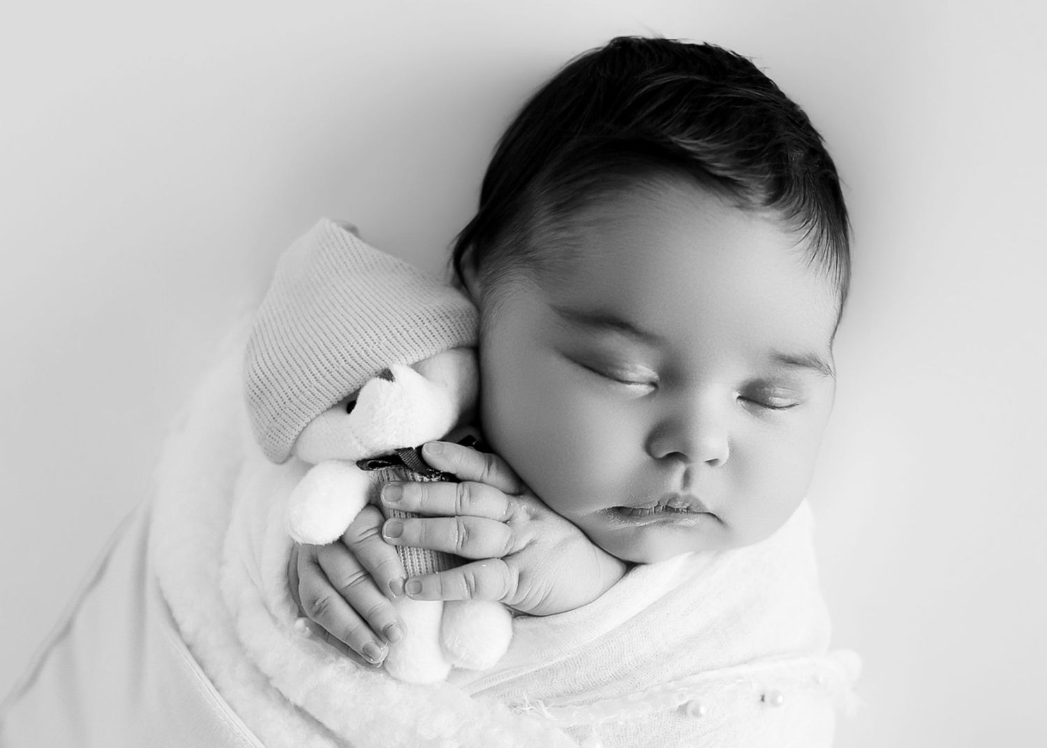 A series of black and white photos showing a sleeping baby in peaceful repose. Redmond Oregon Studio