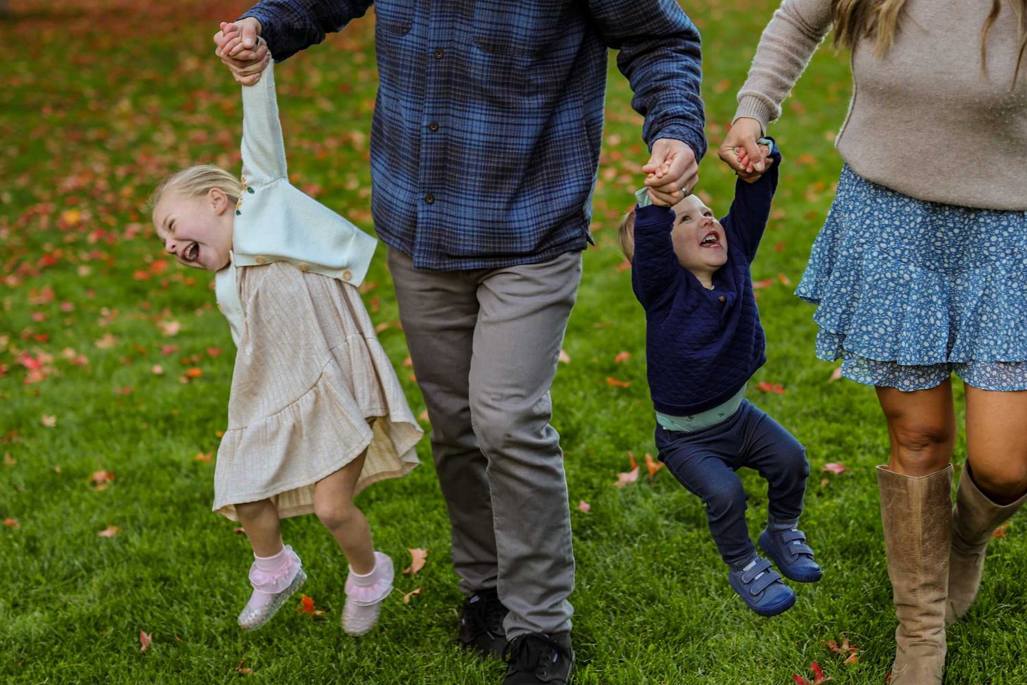 Family swinging two young children by their hands while walking at Hollinshead Park, Bend Oregon