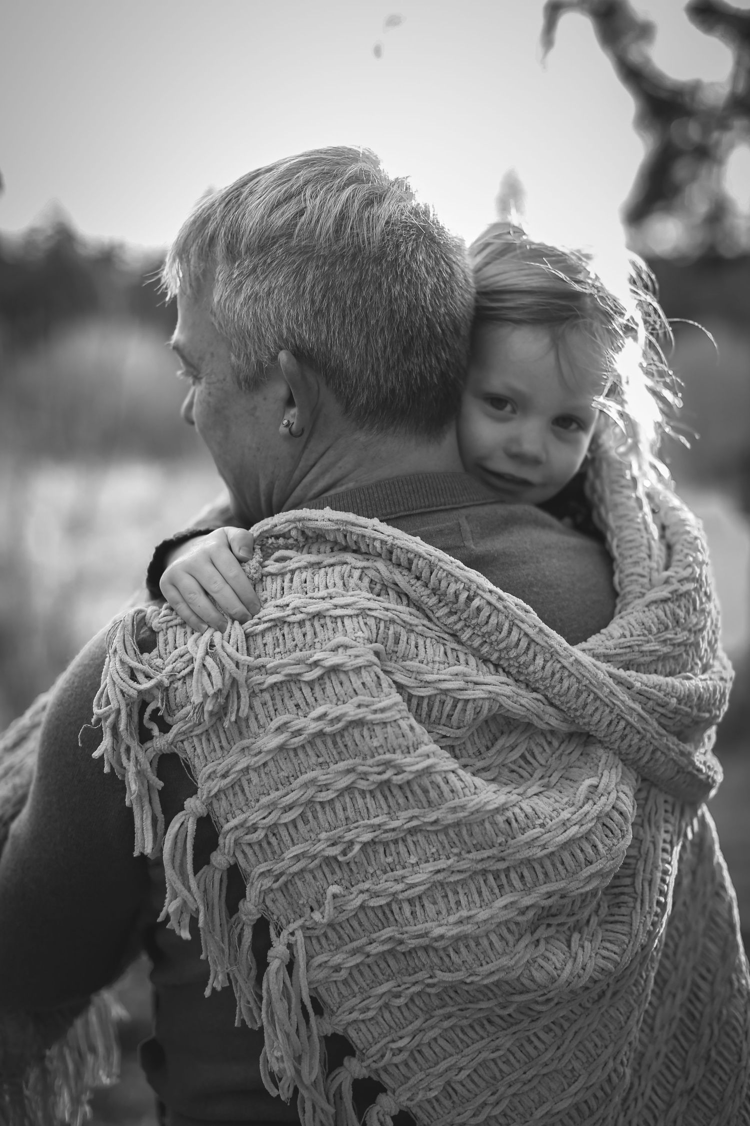 black-and-white-photo-of-dad-holding-daughter-snuggled-under-blanket-bend-oregon-photography