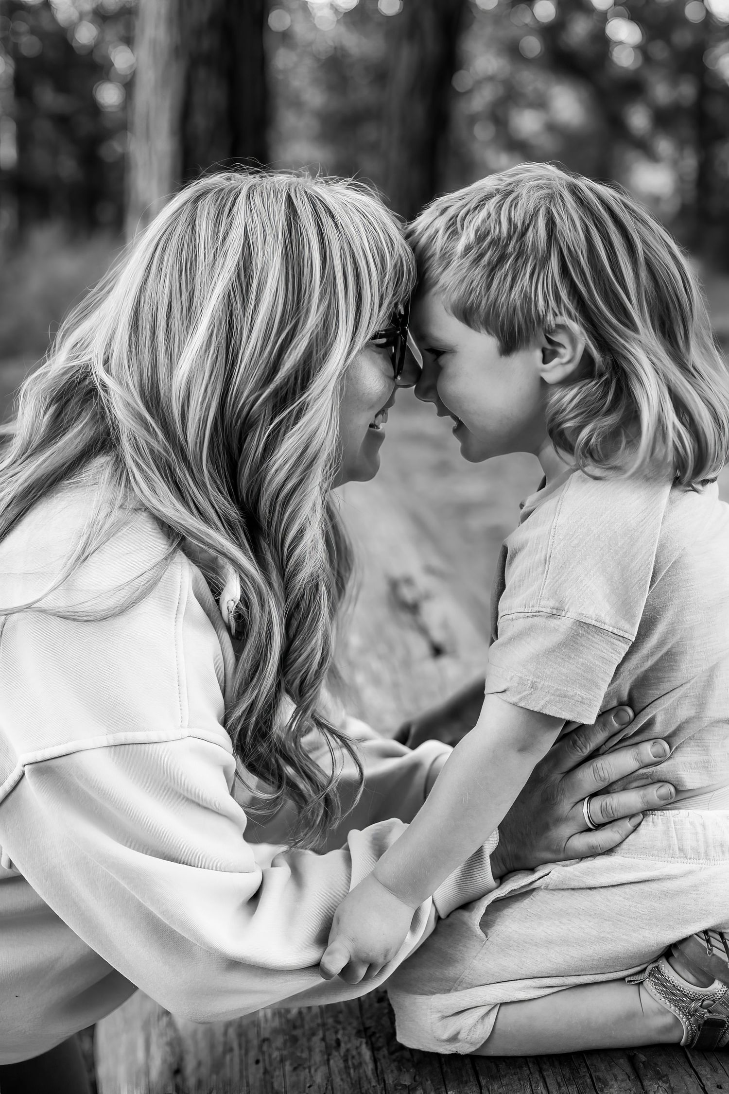 Black and white photo of a mother and young child touching foreheads, sharing a tender moment outdoors. Shevlin Park Bend Oregon
