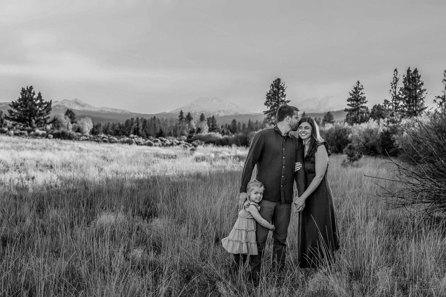 Black and white family photo of couple with toddler in mountain meadow at Indian Ford Meadows, Sisters Oregon