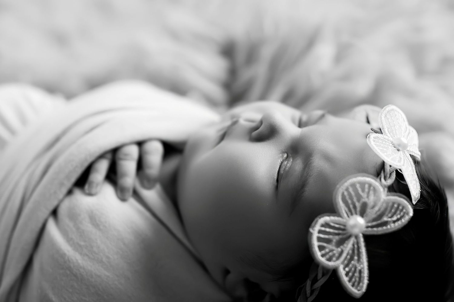 A series of dreamy portraits featuring a baby with decorative butterfly accessories in soft focus.