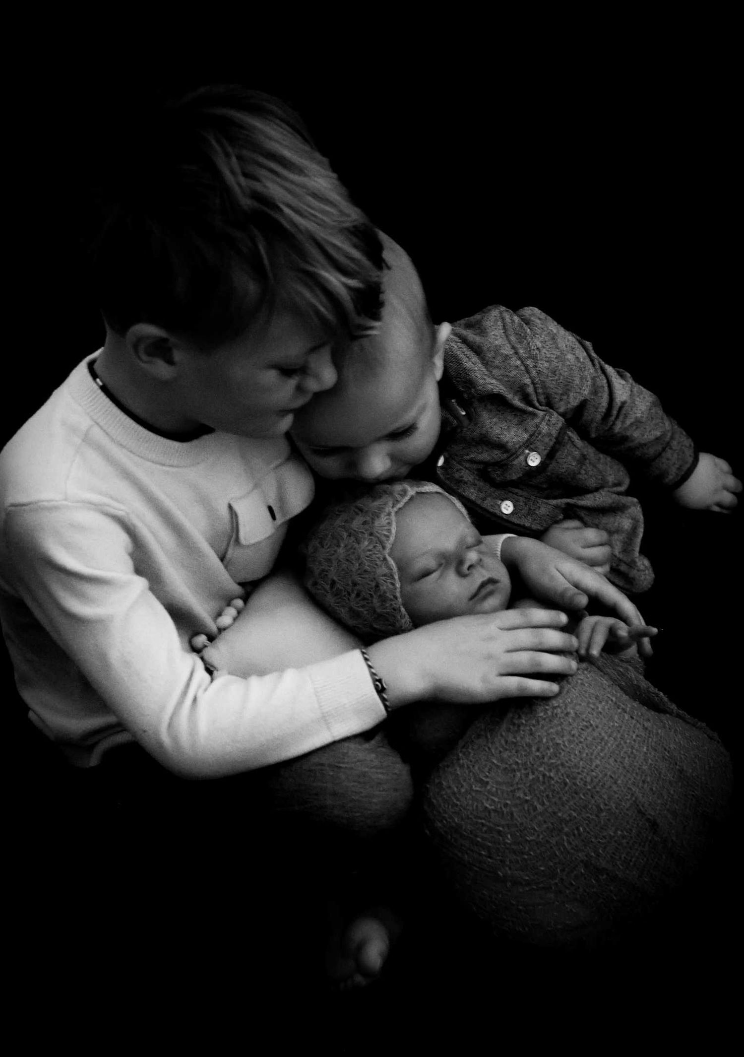 Black and white photos showing tender moments of children sleeping peacefully together.