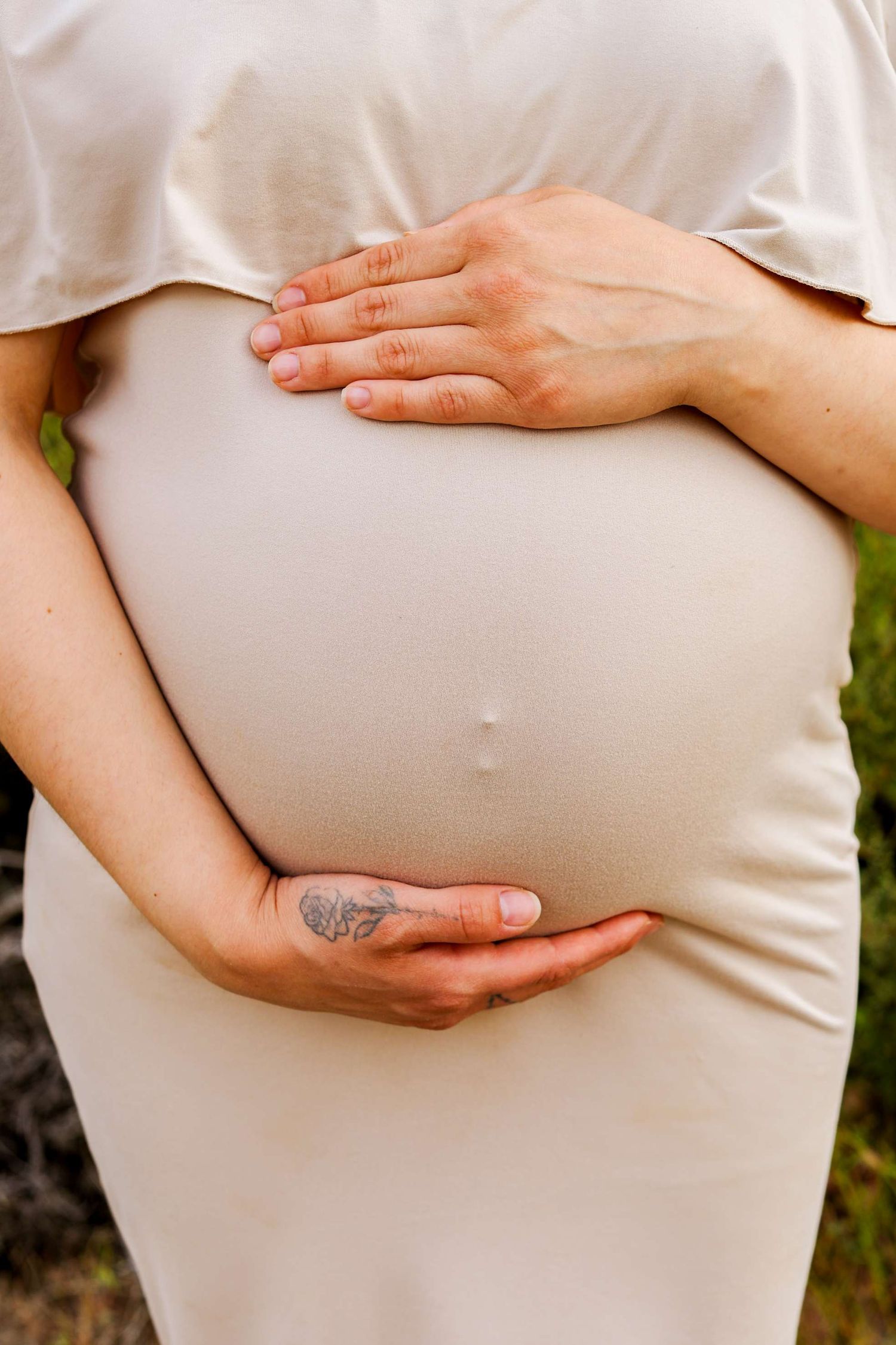 Hands gently cradling a pregnant belly in a series of intimate maternity photos against a natural background.
