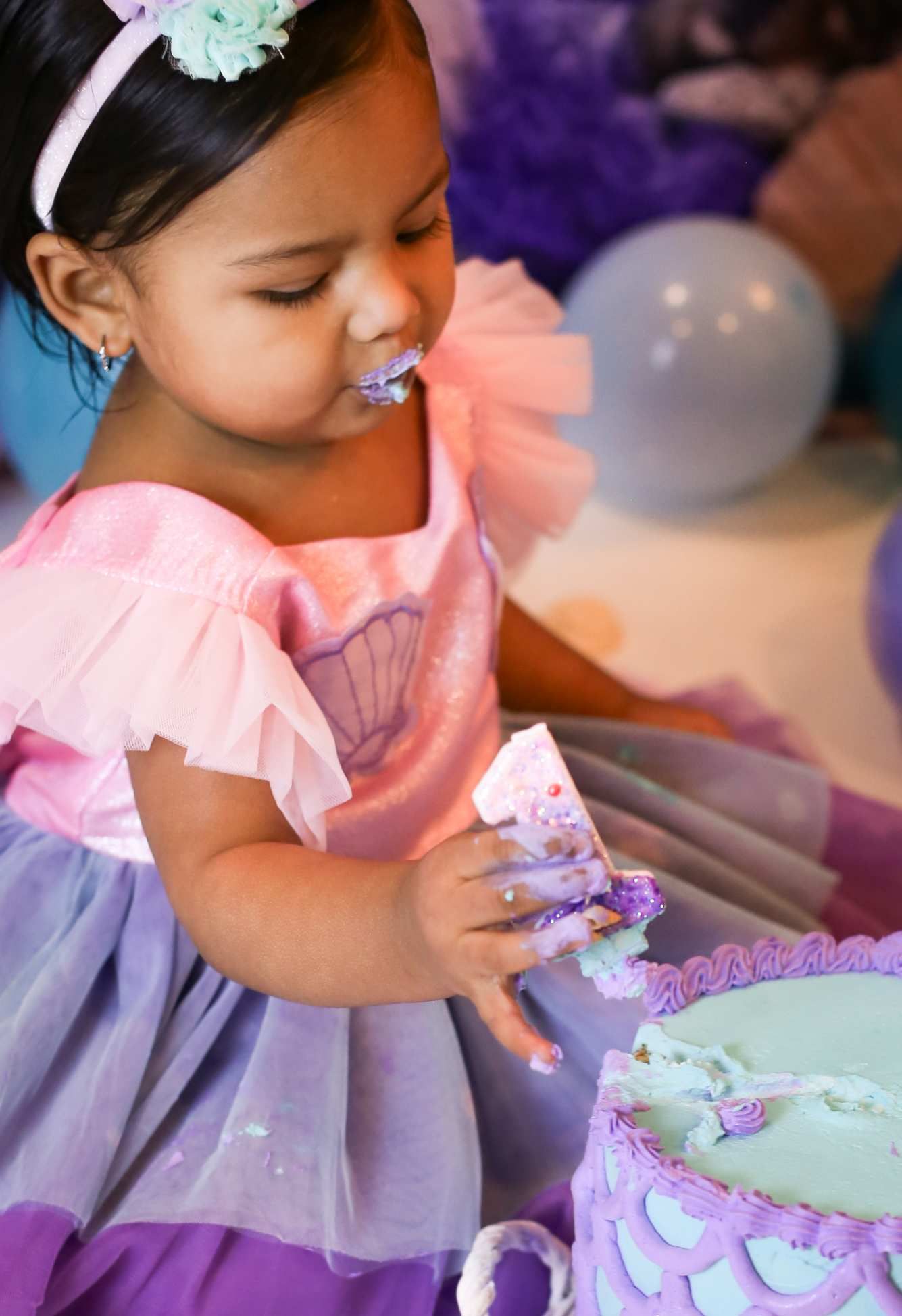 Close-up shots of birthday cake decorating with purple and pink frosting details.