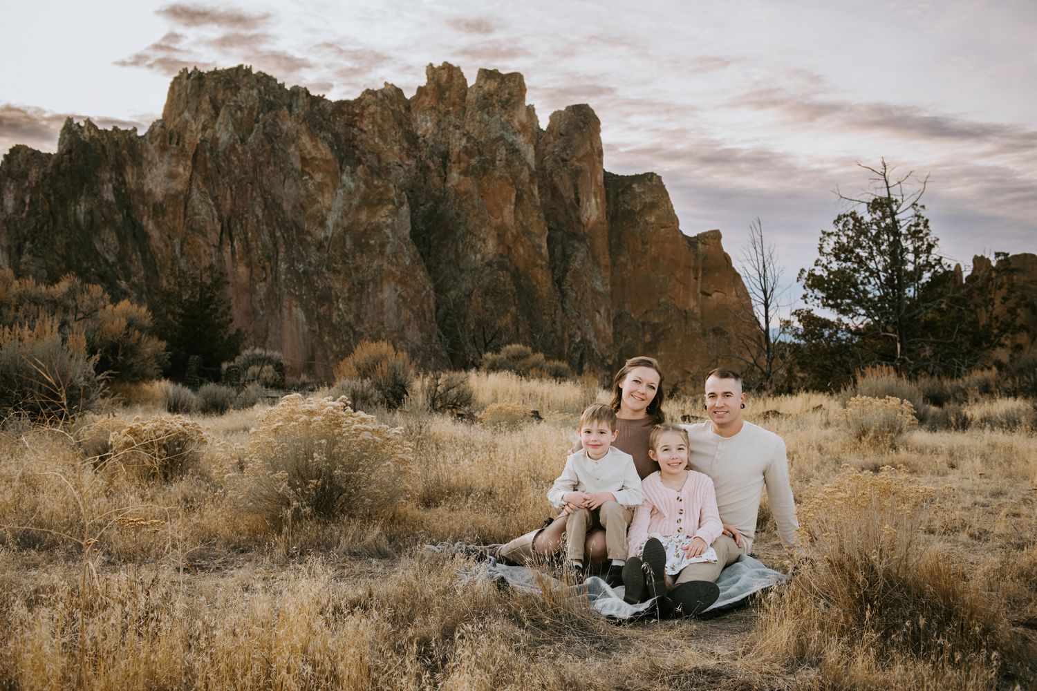 A couple shares an intimate moment among desert rock formations during a golden hour photo session. Smith Rock State Park
