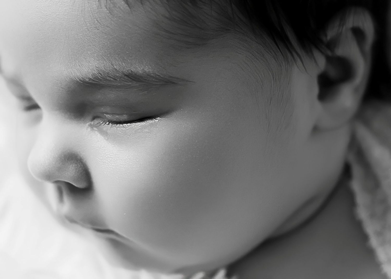 Black and white close-up series showing peaceful sleeping newborn details in soft focus.