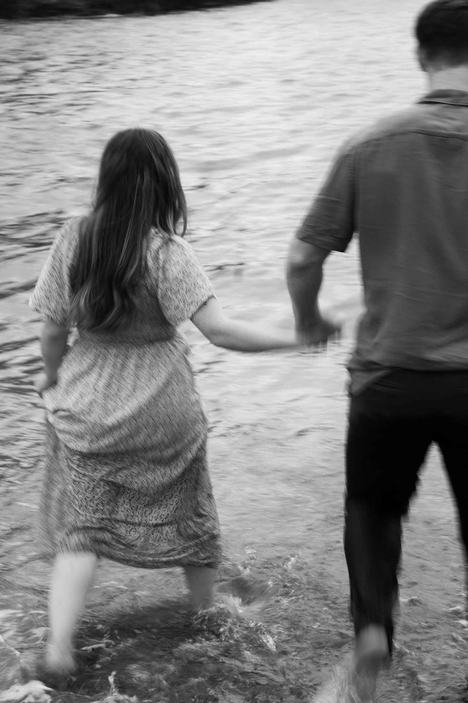 A motion blur photo of a couple running into the sea Park Head near Porthcothan Bay in Cornwall.