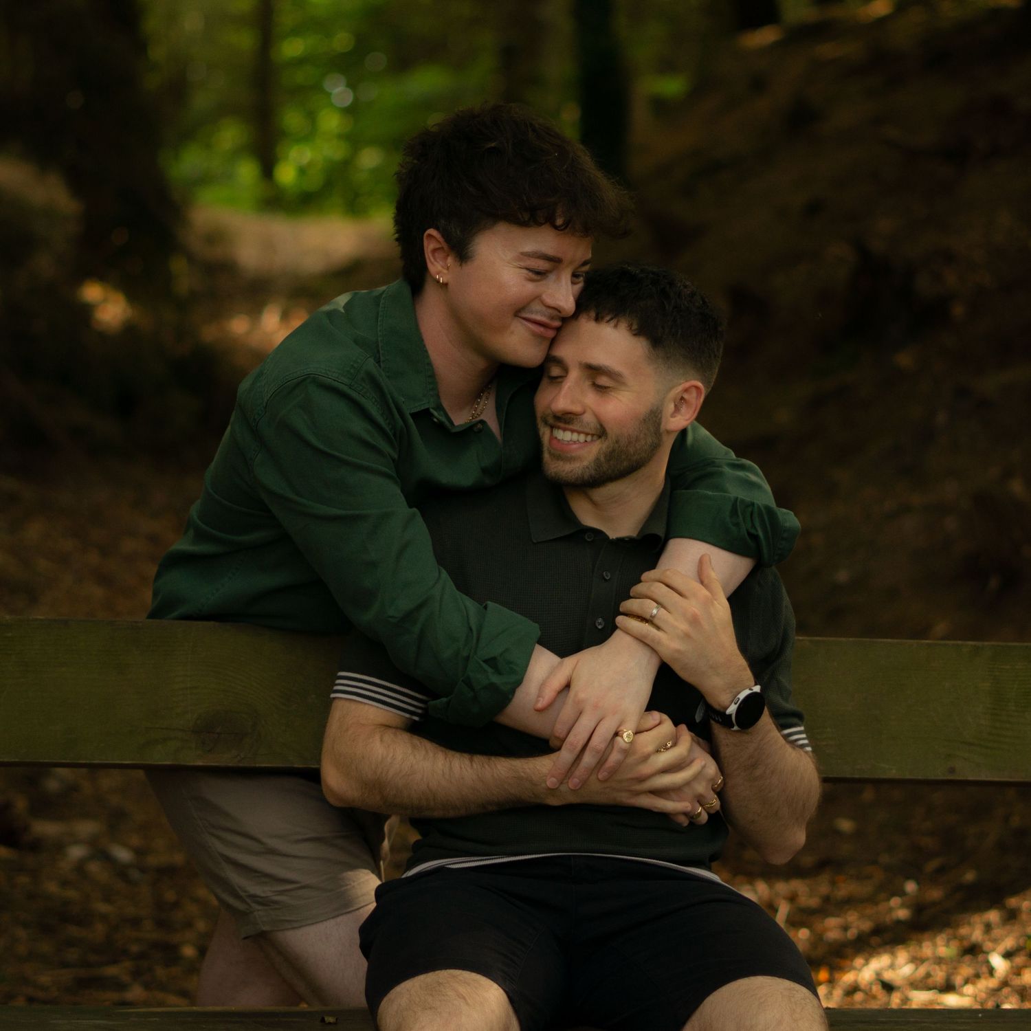 Two men cuddling on a bench in Haldon Forest Park, Devon.