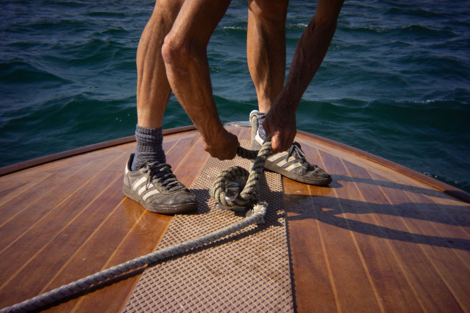 Man tying his vintage speedboats in Padstow, Cornwall.