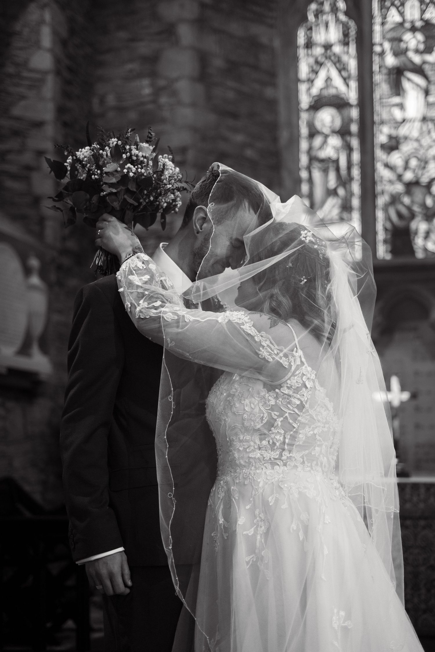 The first kiss between bride and groom at their wedding in St Peter's Church, Berrynarber, North Devon.