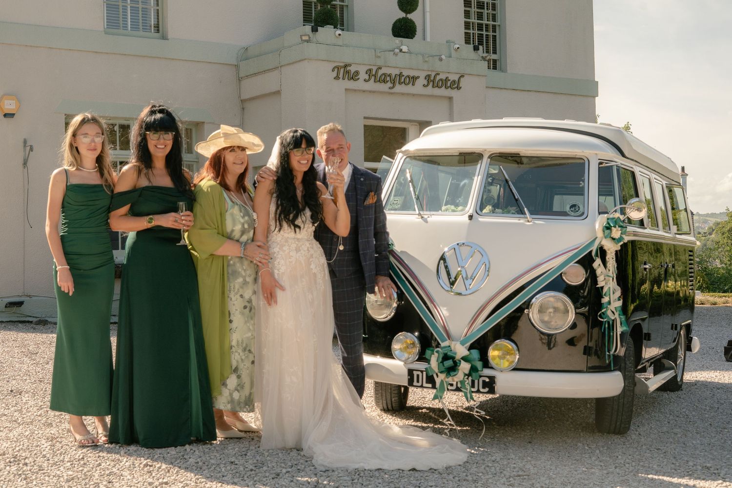 The bride and her family smiling in front of her VW campervan wedding car, at the Haytor Hotel, Torquay.