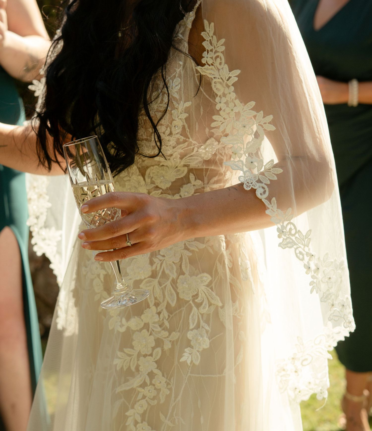 Details of the bride's dress, with golden light shining through lace.