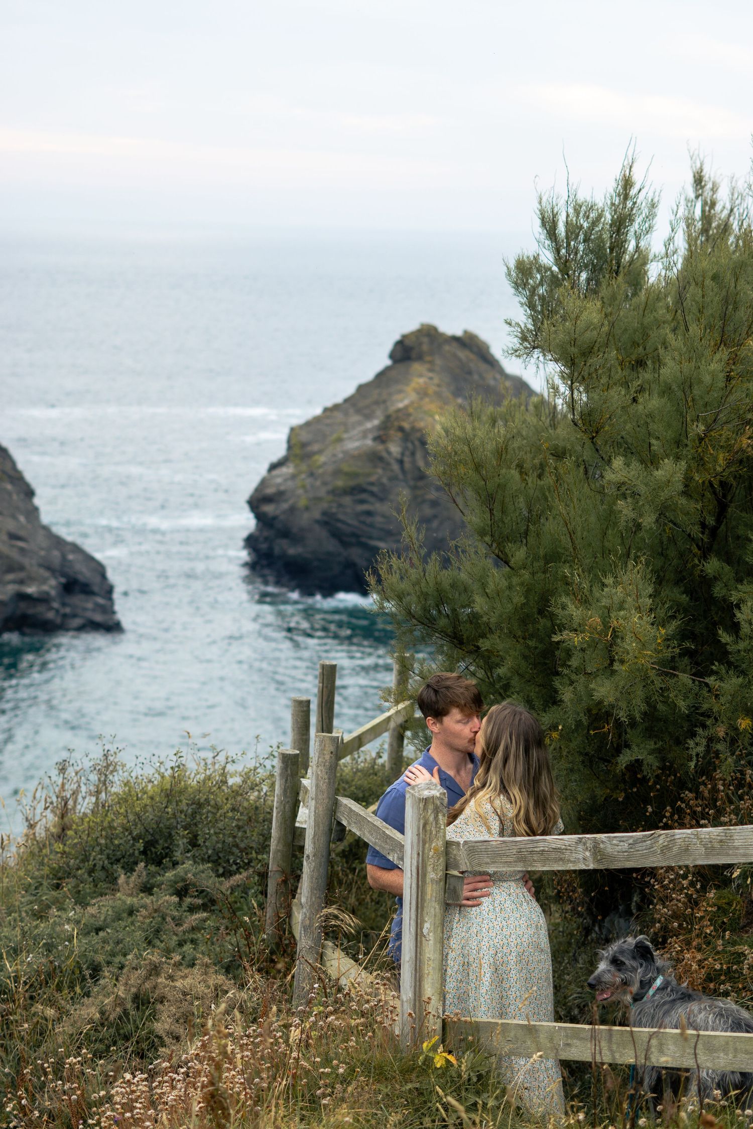A couple kiss whilst walking the South West Coastal Path at Park Head near Porthcothan Bay in Cornwall.