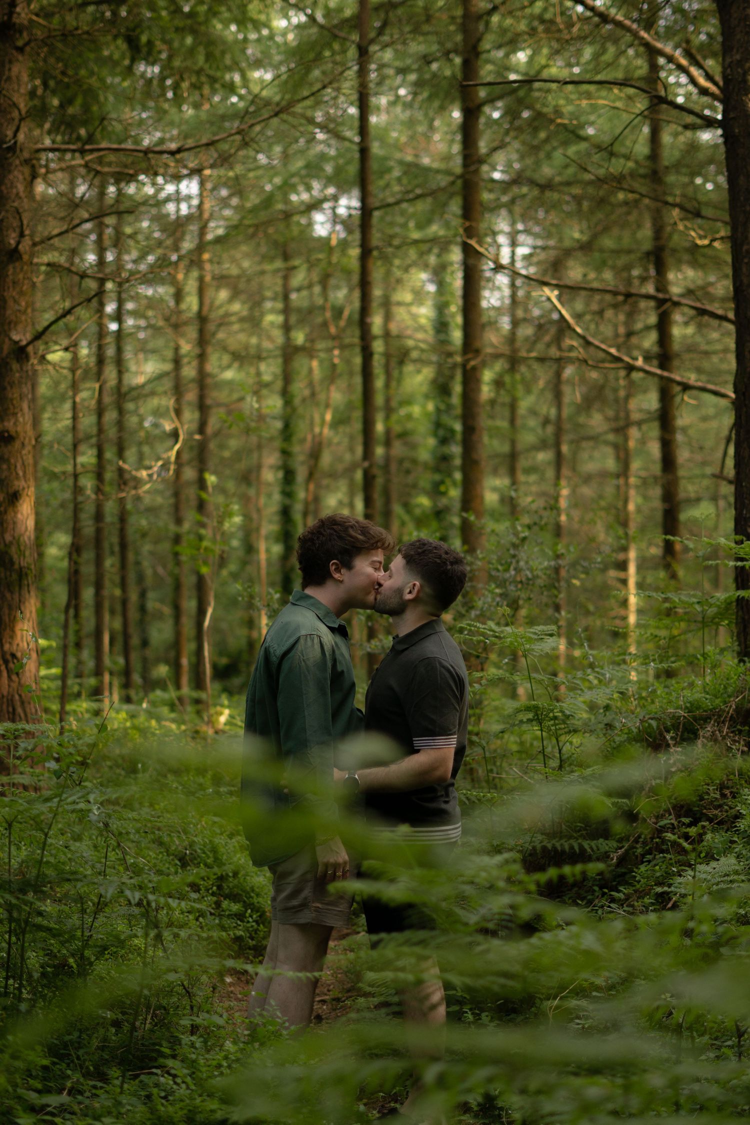A gay couple kissing in the Haldon Forest Park, Devon.