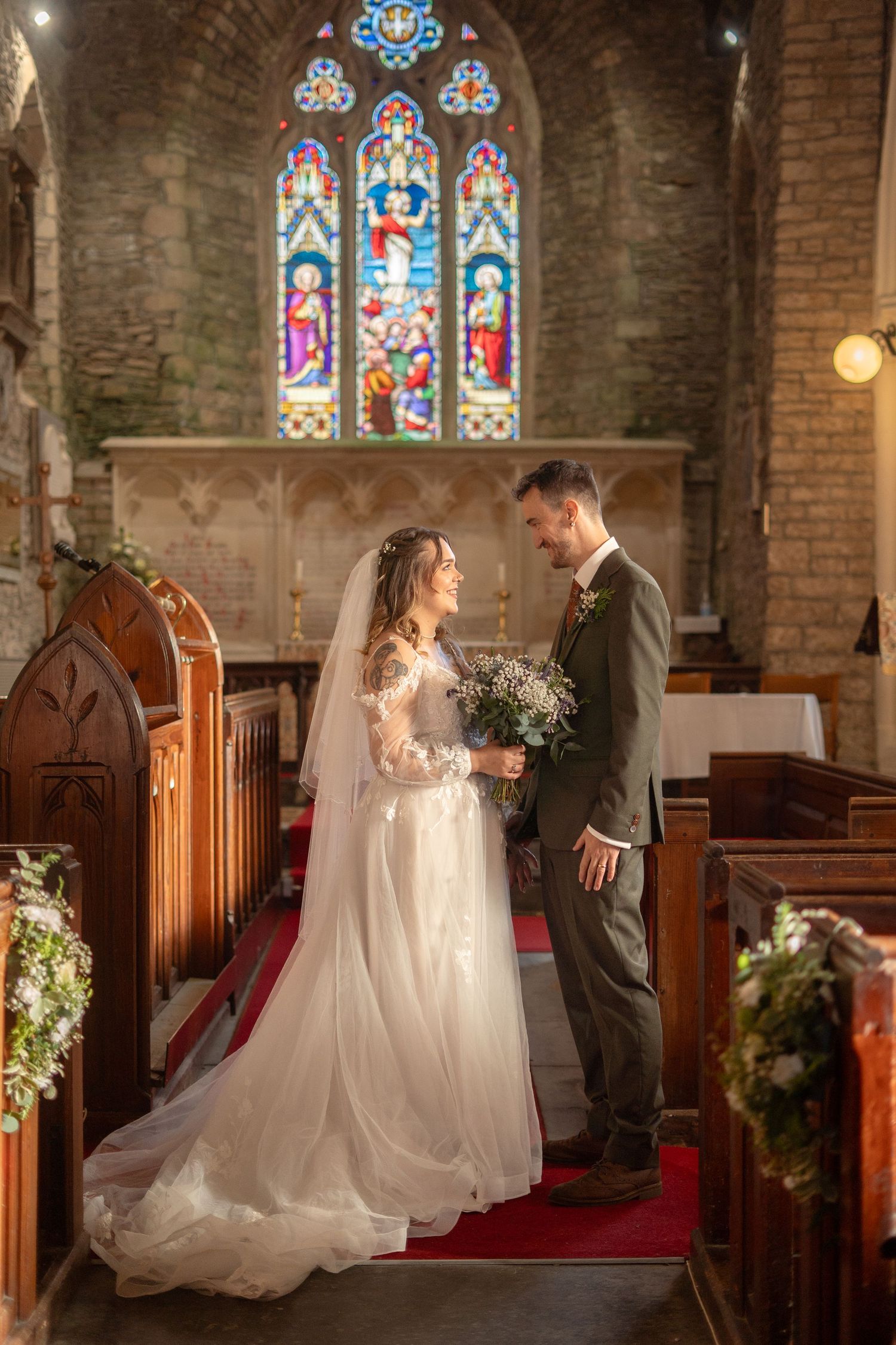 Bride and groom look into each others eyes and share a romantic moment during their wedding at St Peter's Church, Berrynarber, North Devon.