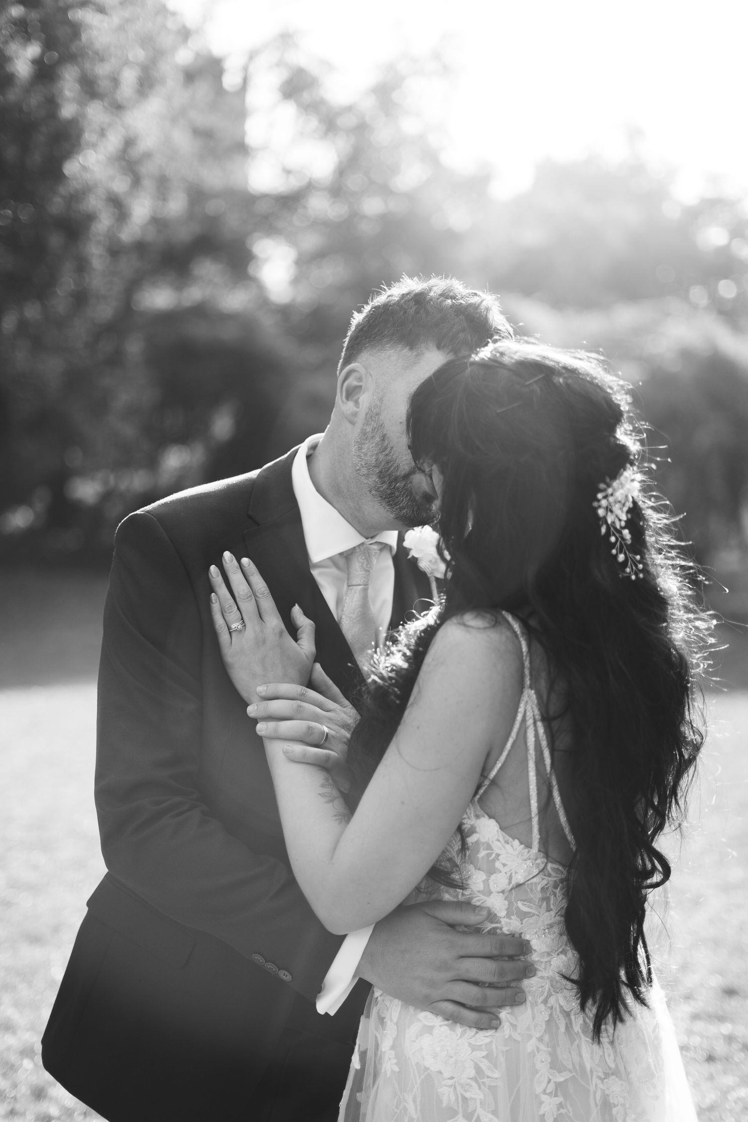 The bride and groom sharing a kiss after their wedding reception at Cockington Court, Torquay, England.