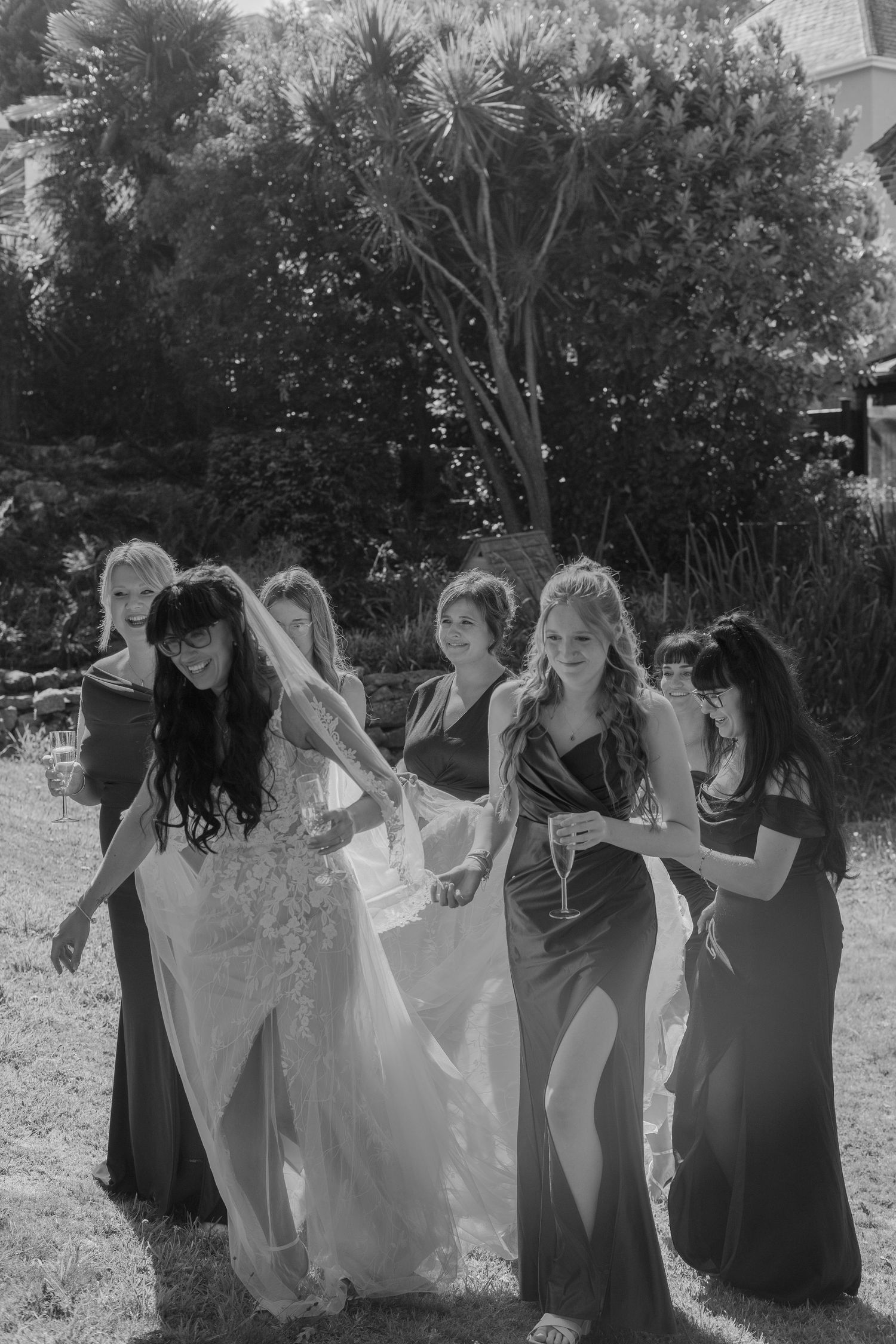 Bridesmaids helping to carry the bride's dress and veil.