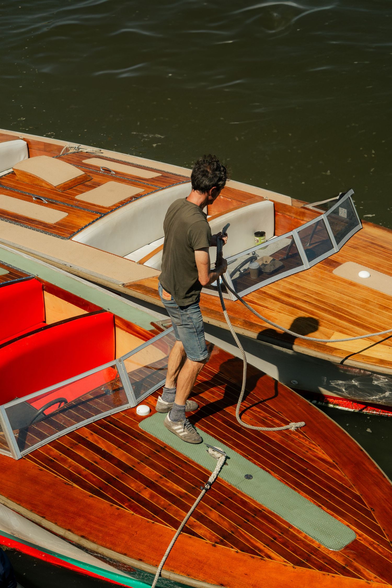 Man tying his vintage speedboats in Padstow, Cornwall.