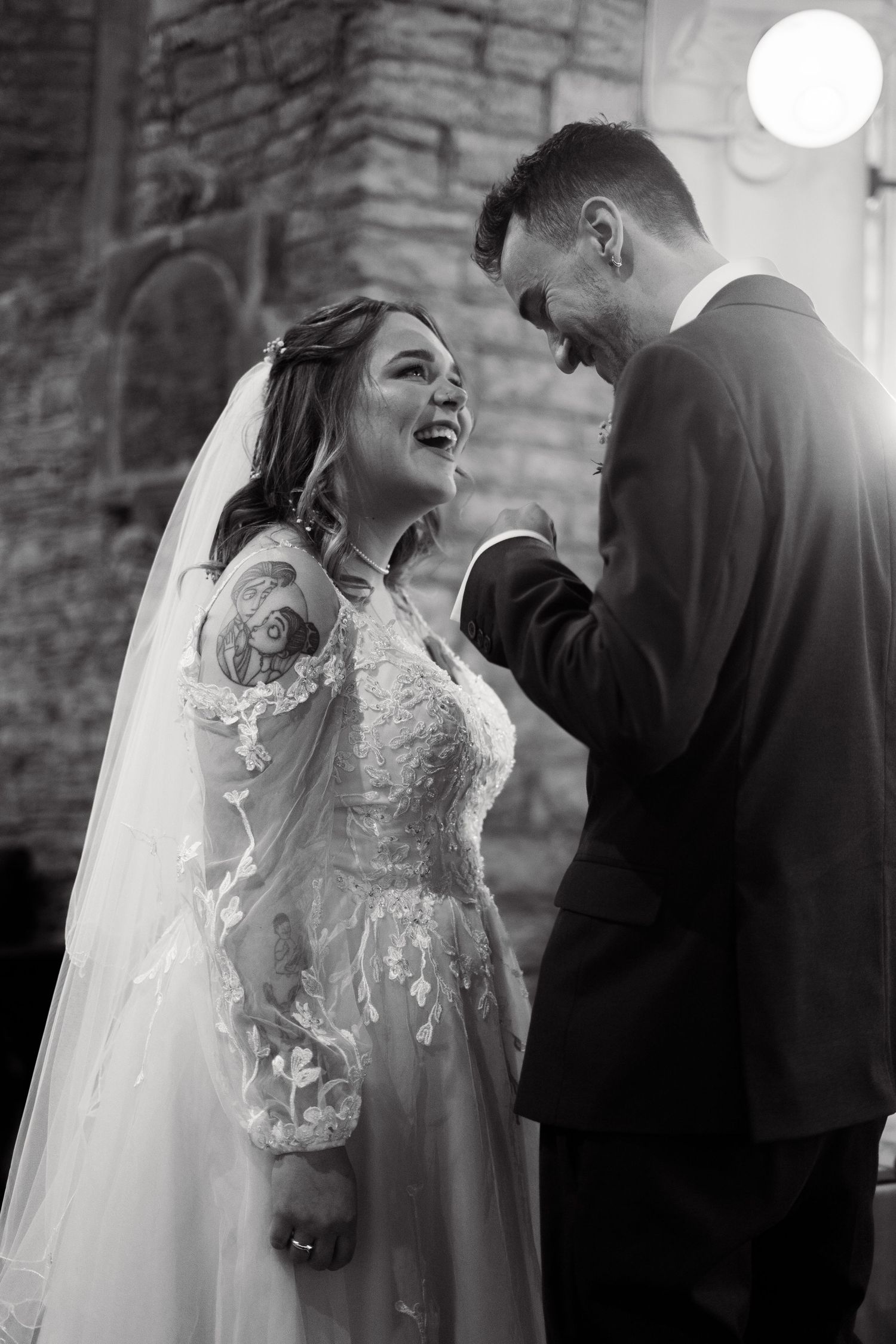 The bride and groom sharing a laugh at the alter, shortly after their ceremony in St Peter's Church, Berrynarber, North Devon.