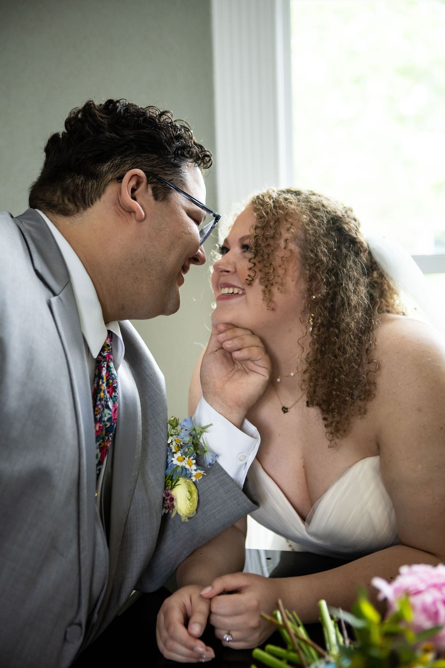 Romantic wedding portrait moment against interior window light.