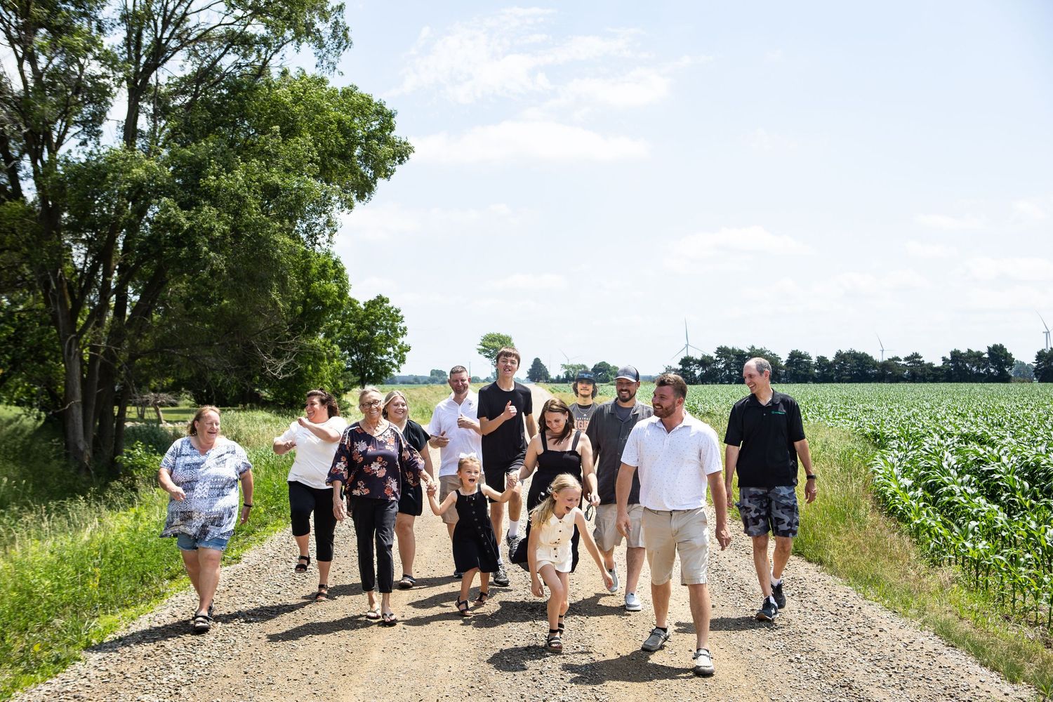 Group walking along a rural dirt path on a sunny summer day.