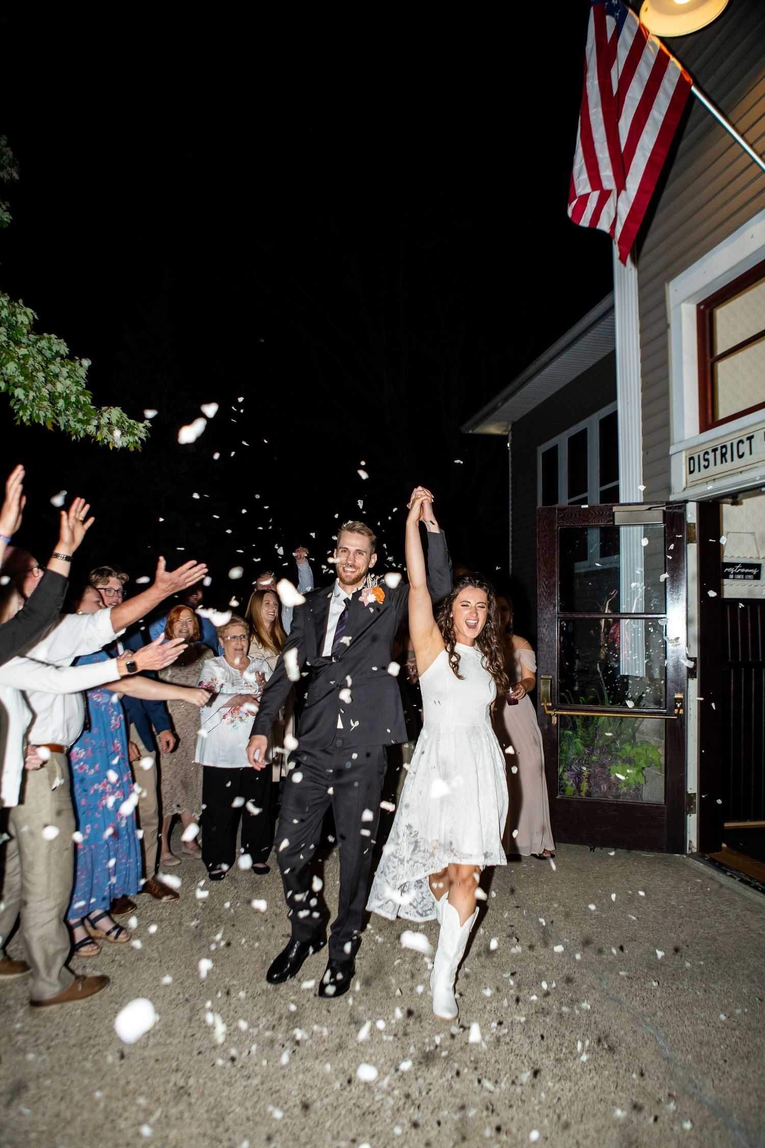A sequence of wedding celebration photos showing people throwing white rose petals in front of an American flag at night.