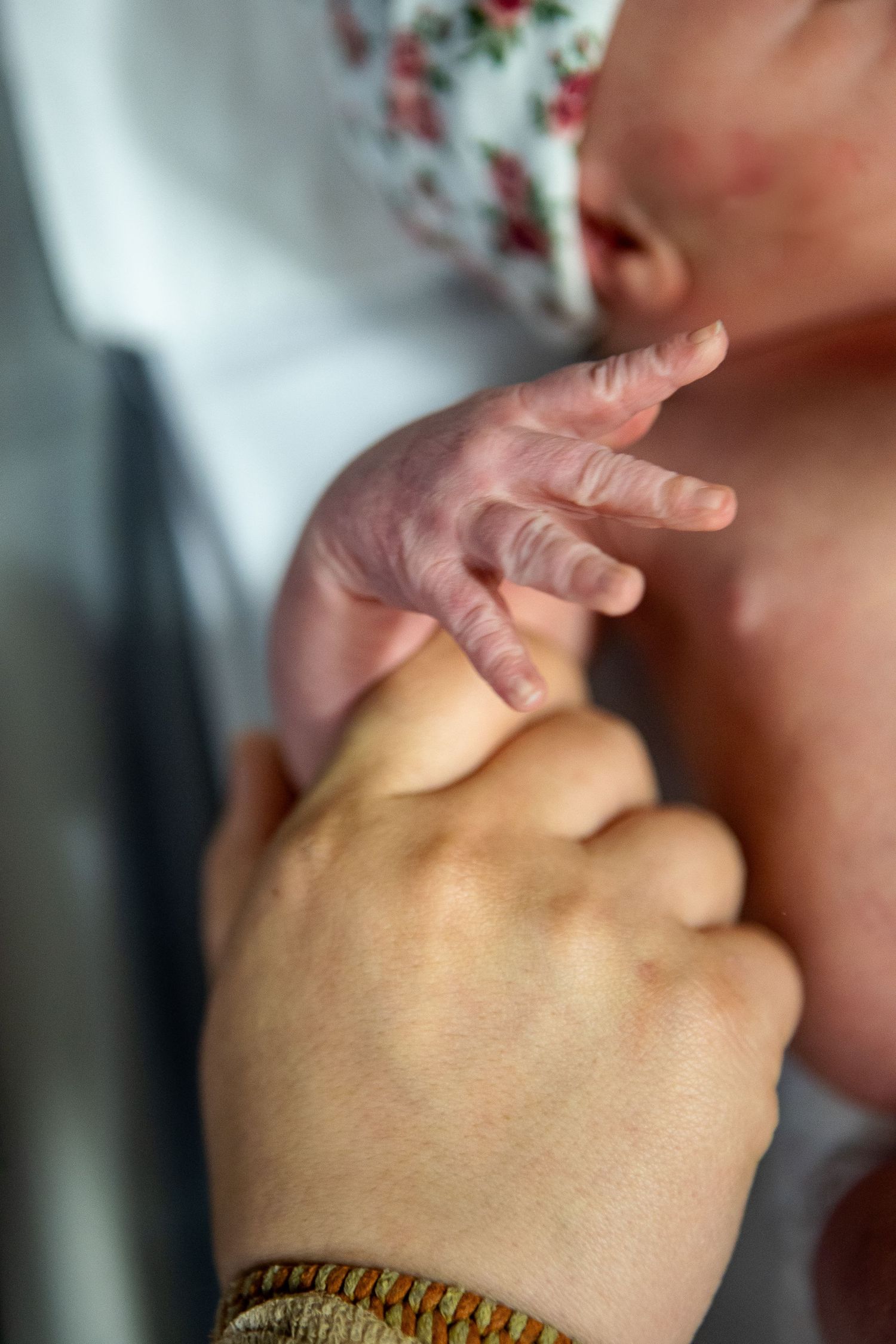 Close-up of gentle hand holding and comforting a small baby.