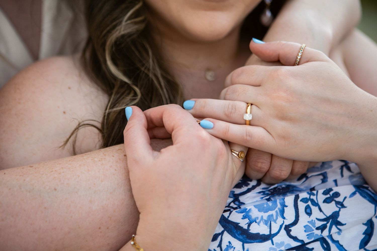 Close-up shots of hands and rings during romantic engagement photo session.