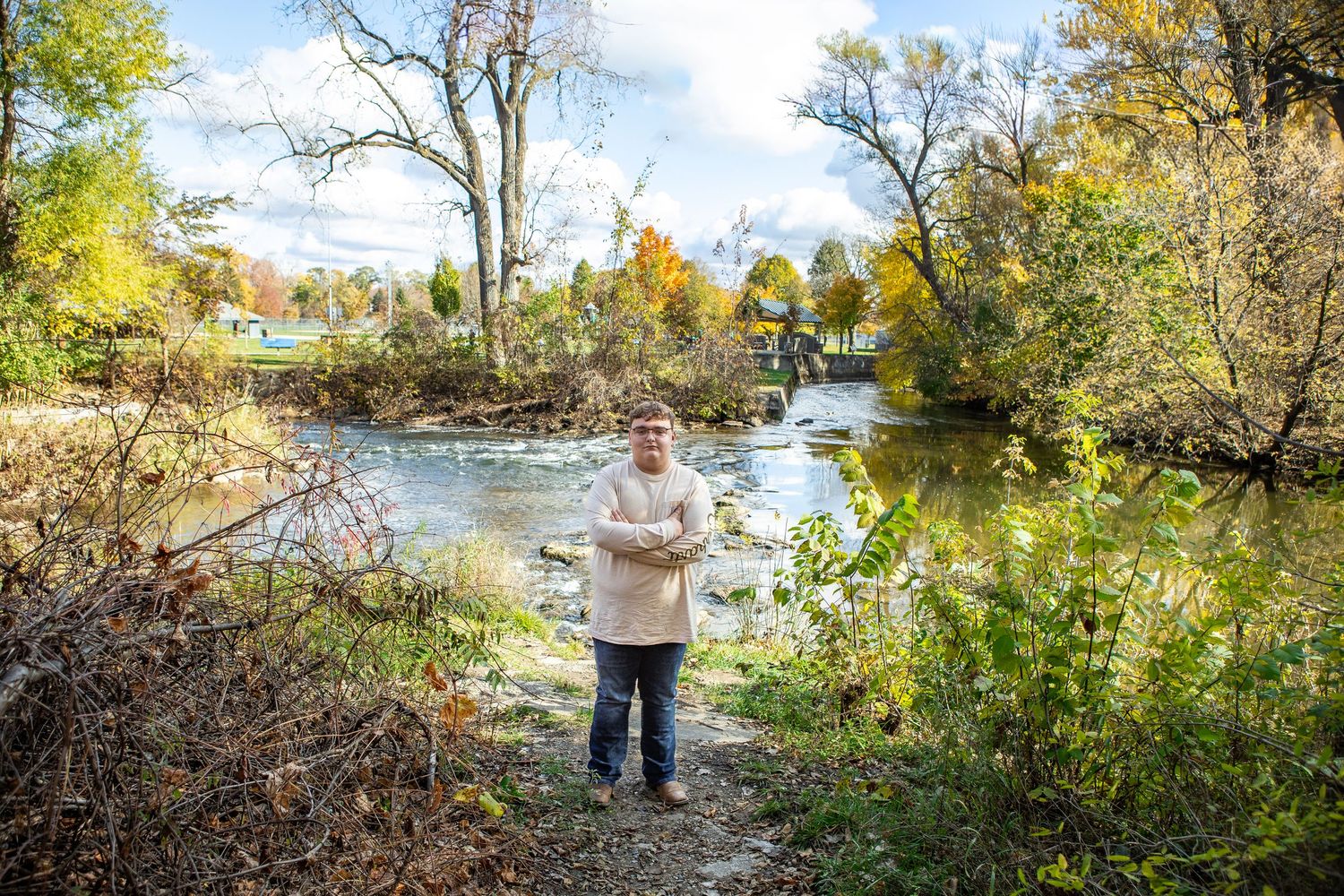 Scenic autumn panorama of a river with colorful fall foliage and trees along the shoreline.