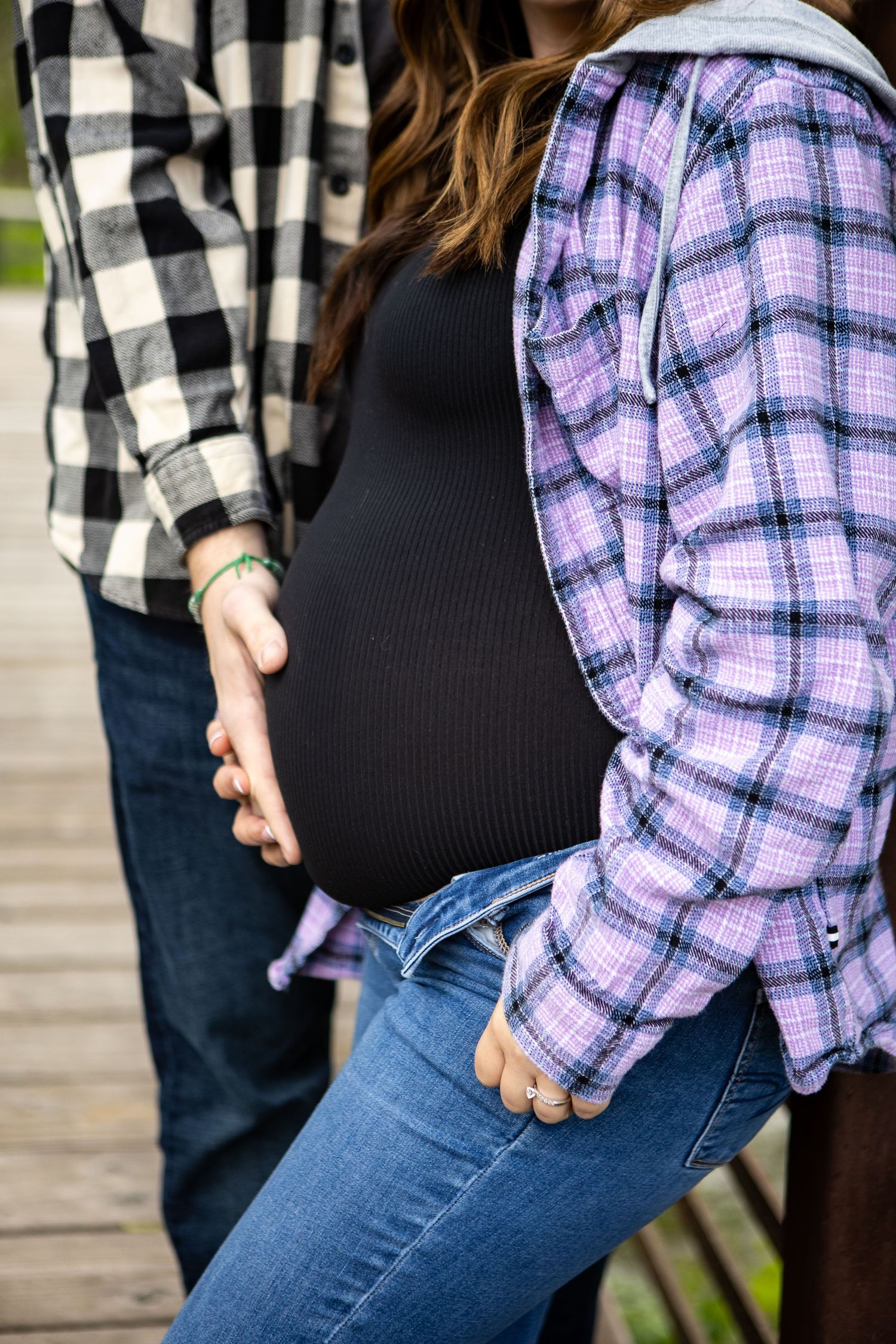 Close-up of casual outfits featuring plaid shirts and jeans in an outdoor setting.