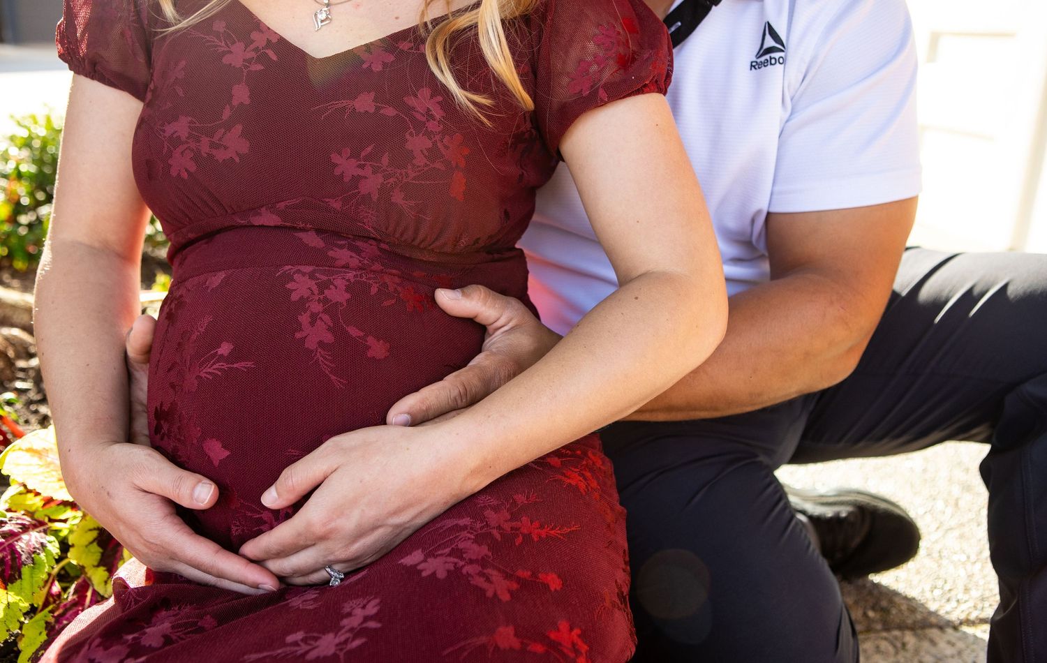 Maternity photo session showing close-up details of burgundy lace dress.