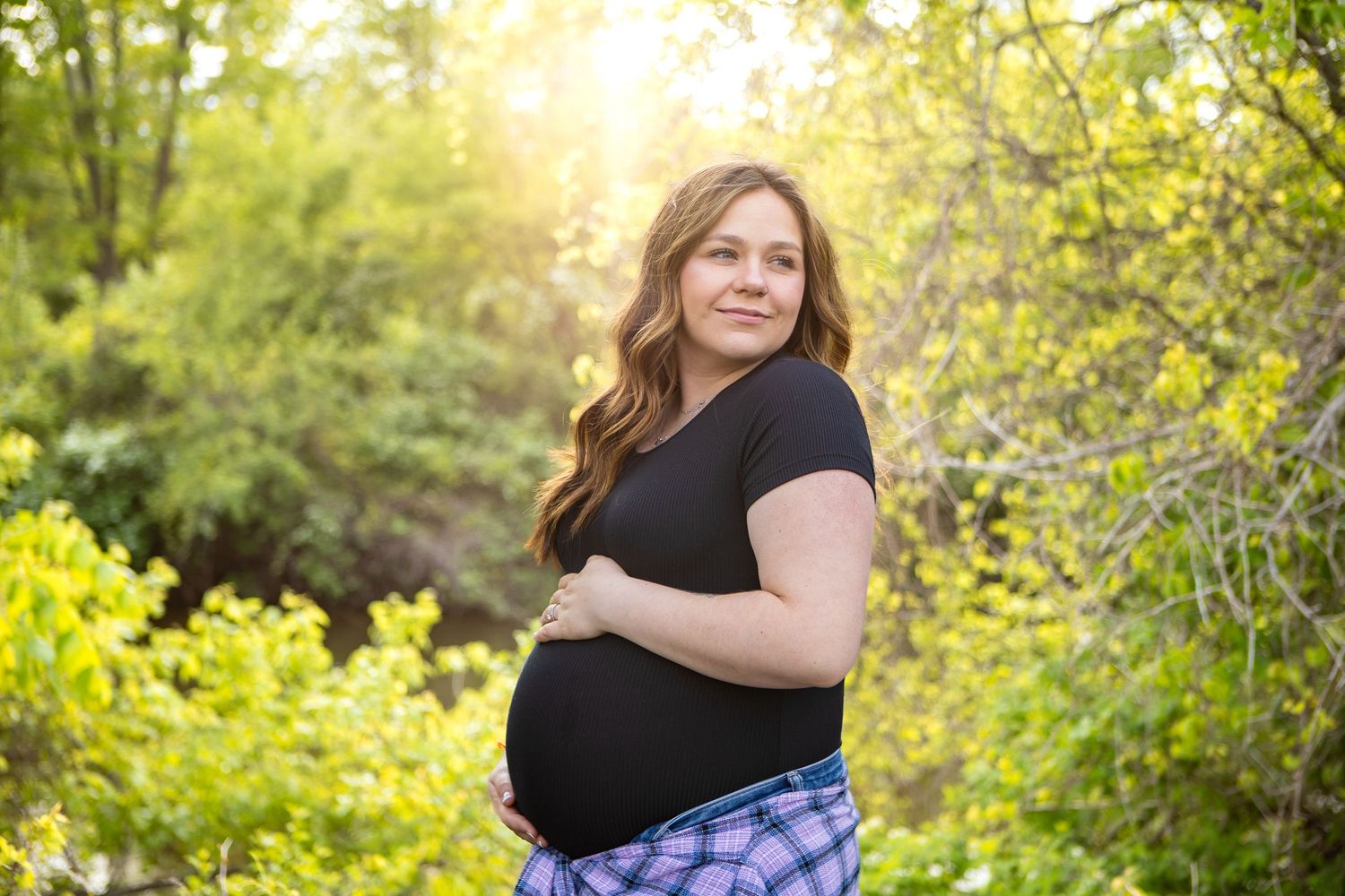 Portrait session in golden sunlit garden with natural spring foliage.