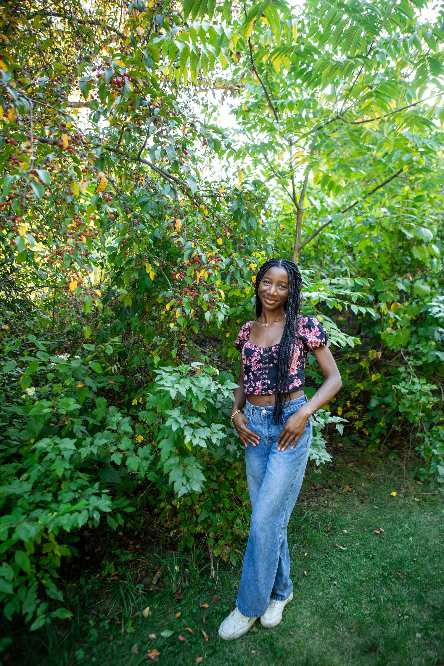 Casual outdoor portrait session in a lush green garden setting with natural lighting.