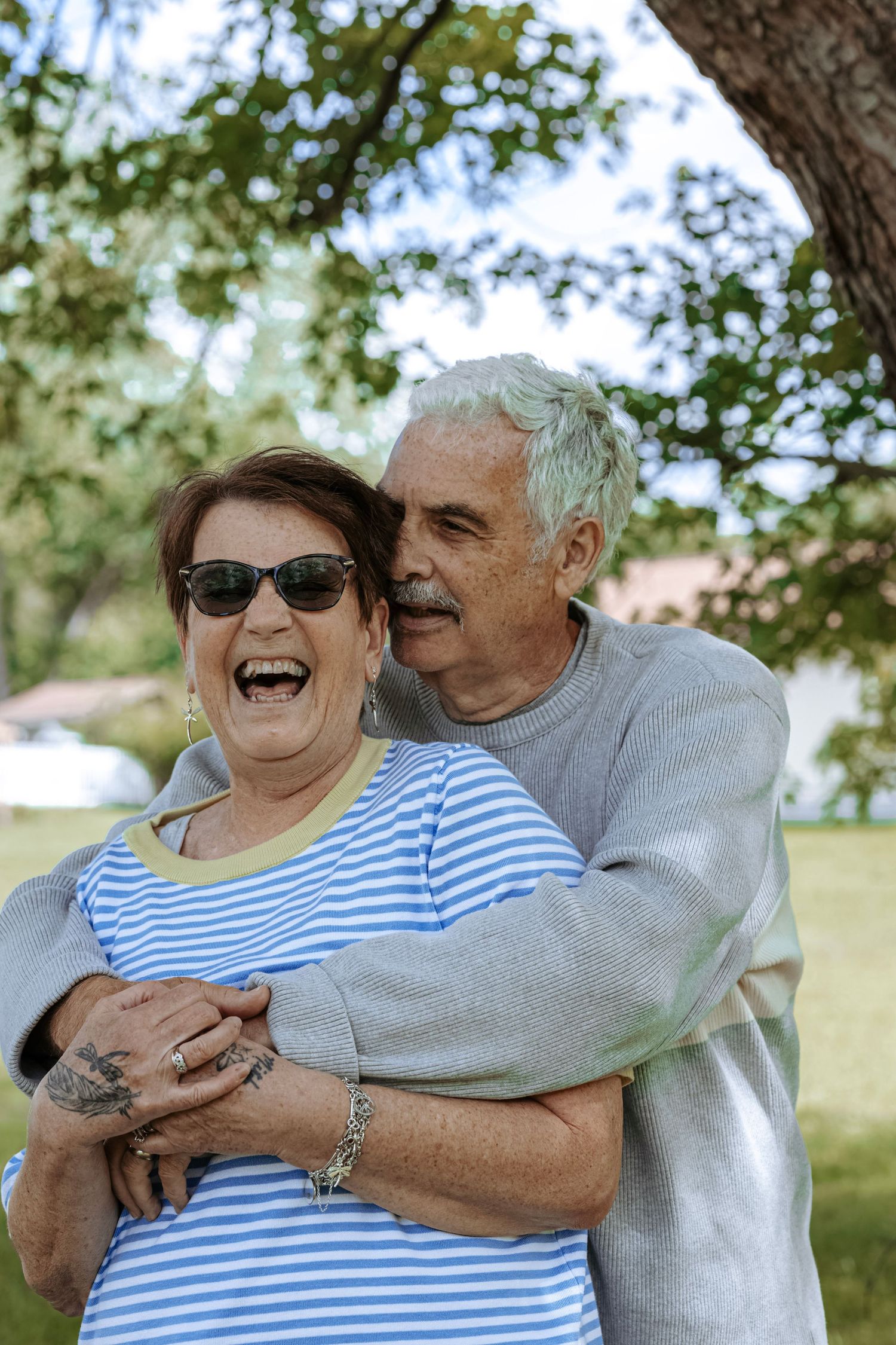 oyful portrait of an older couple laughing and embracing during an outdoor couple photography session.