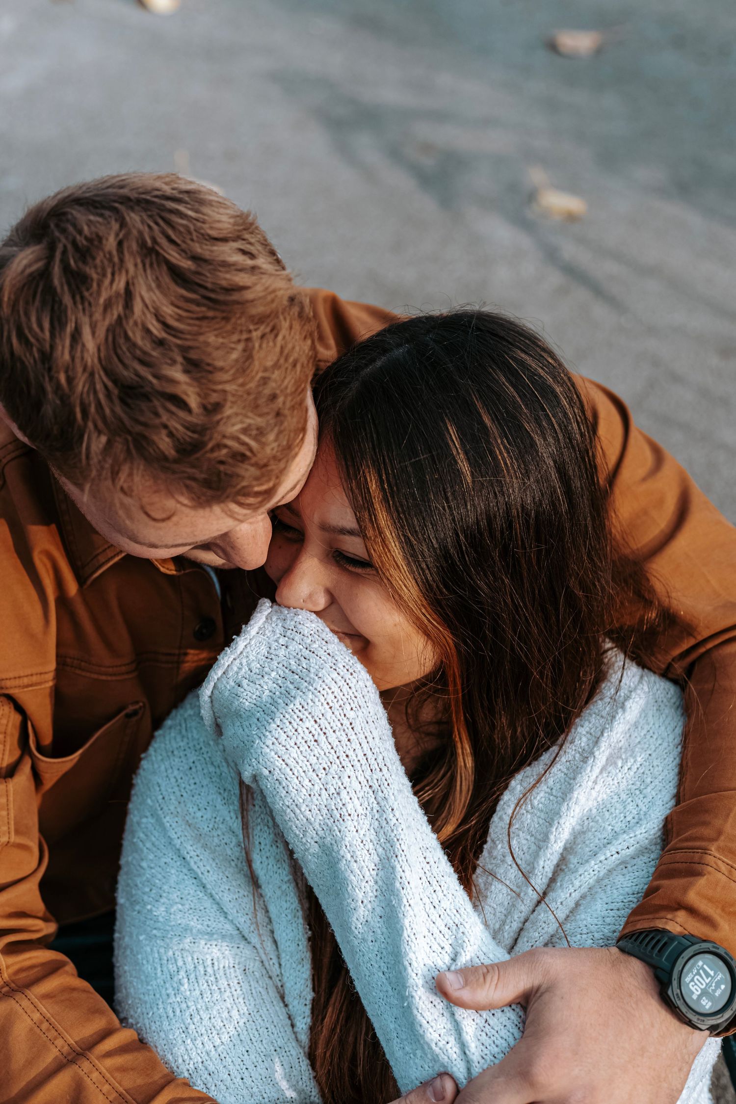 Cozy lifestyle portrait of a couple cuddling together during an intimate outdoor photography session.