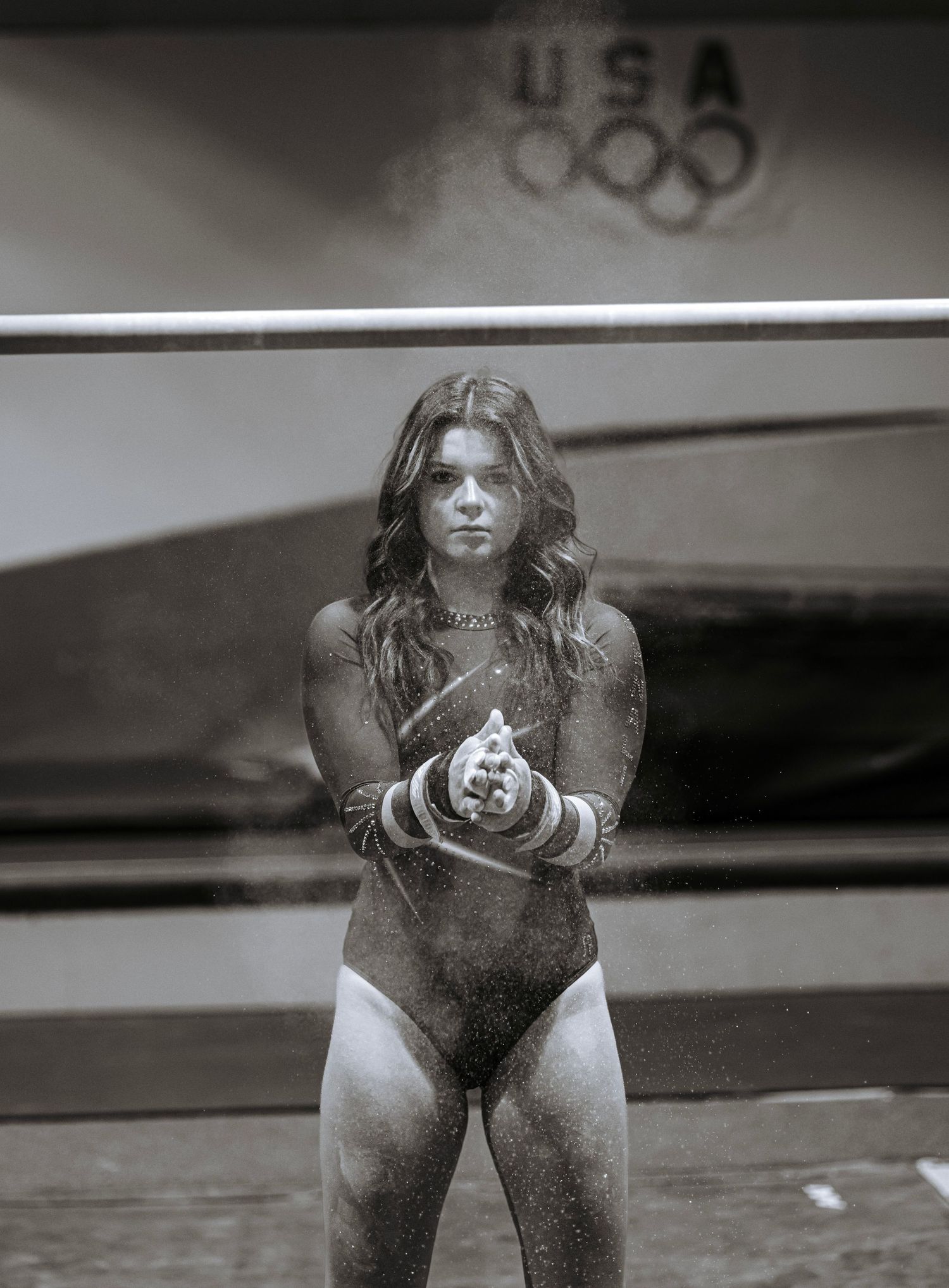 Black and white portrait of a gymnast standing confidently inside a gym during a senior sport session.