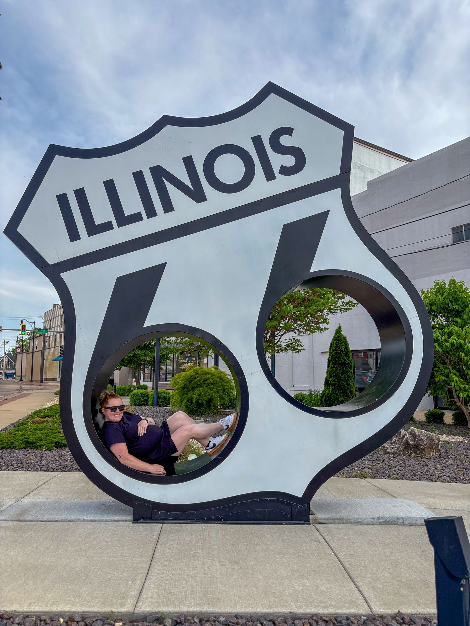 owner of lucky river photography sitting in the Route 66 sign in Illinois