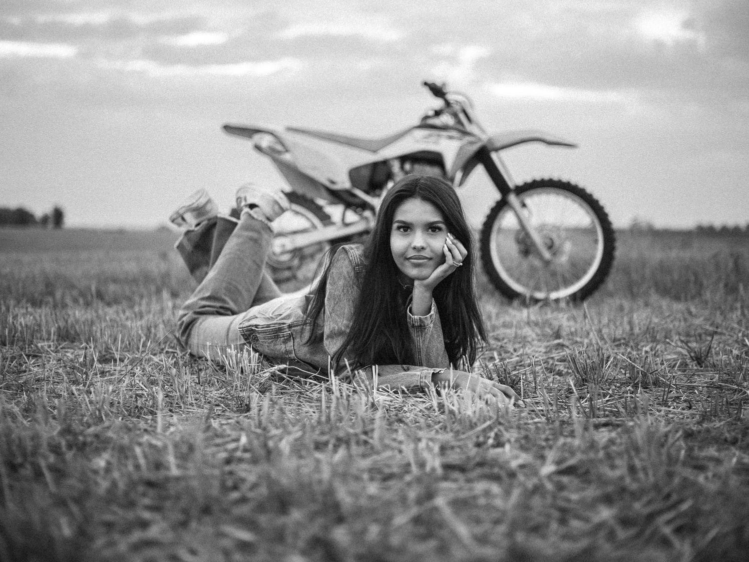 A series of black and white photos showing senior lying in a grassy field next to a dirtbike. photo, Great Falls, MT