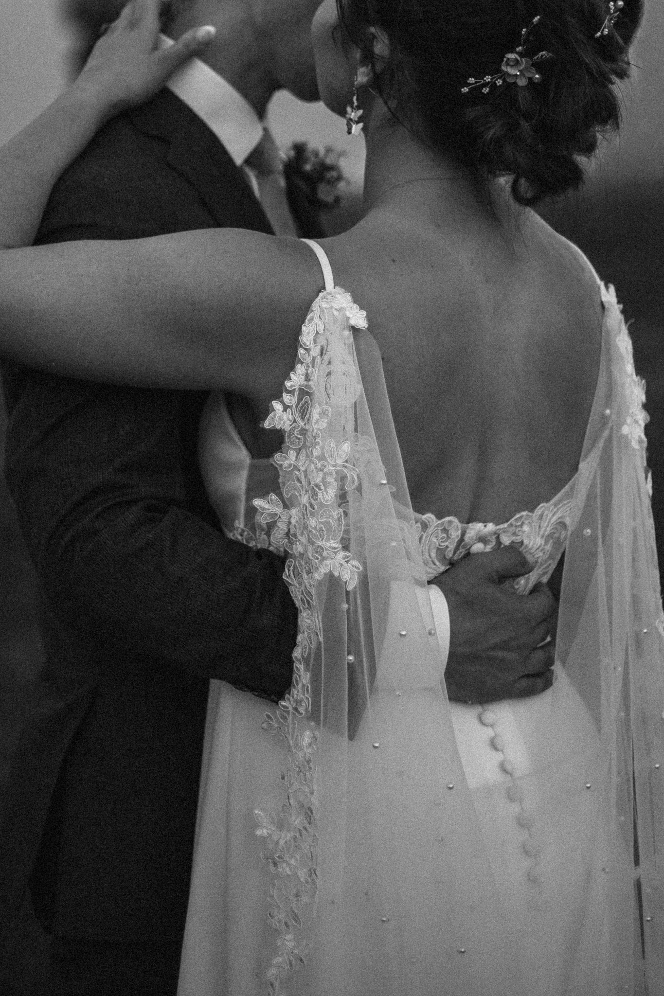 A romantic black and white wedding photo series showing close-up details of a bride and groom embracing. Great Falls, Montana