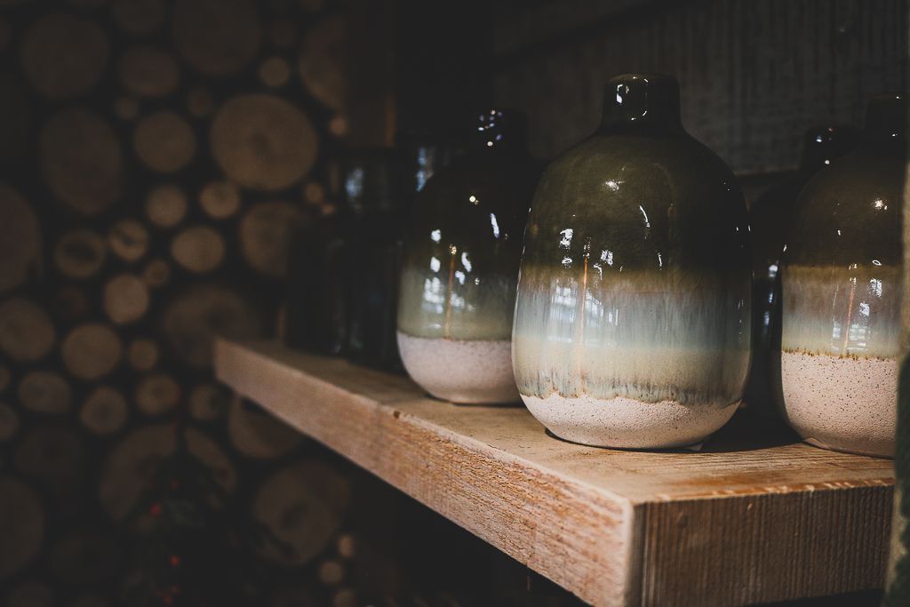 Three glass mason jars with layered contents sit on a rustic wooden shelf against a dark background.