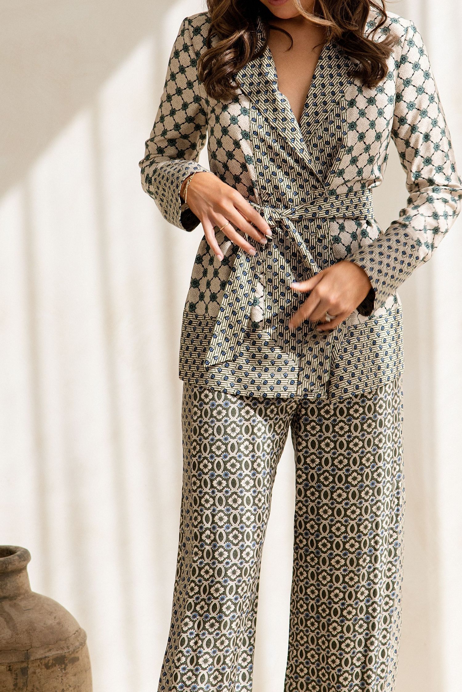 Woman wearing a matching geometric print blazer and wide-leg pants suit set.