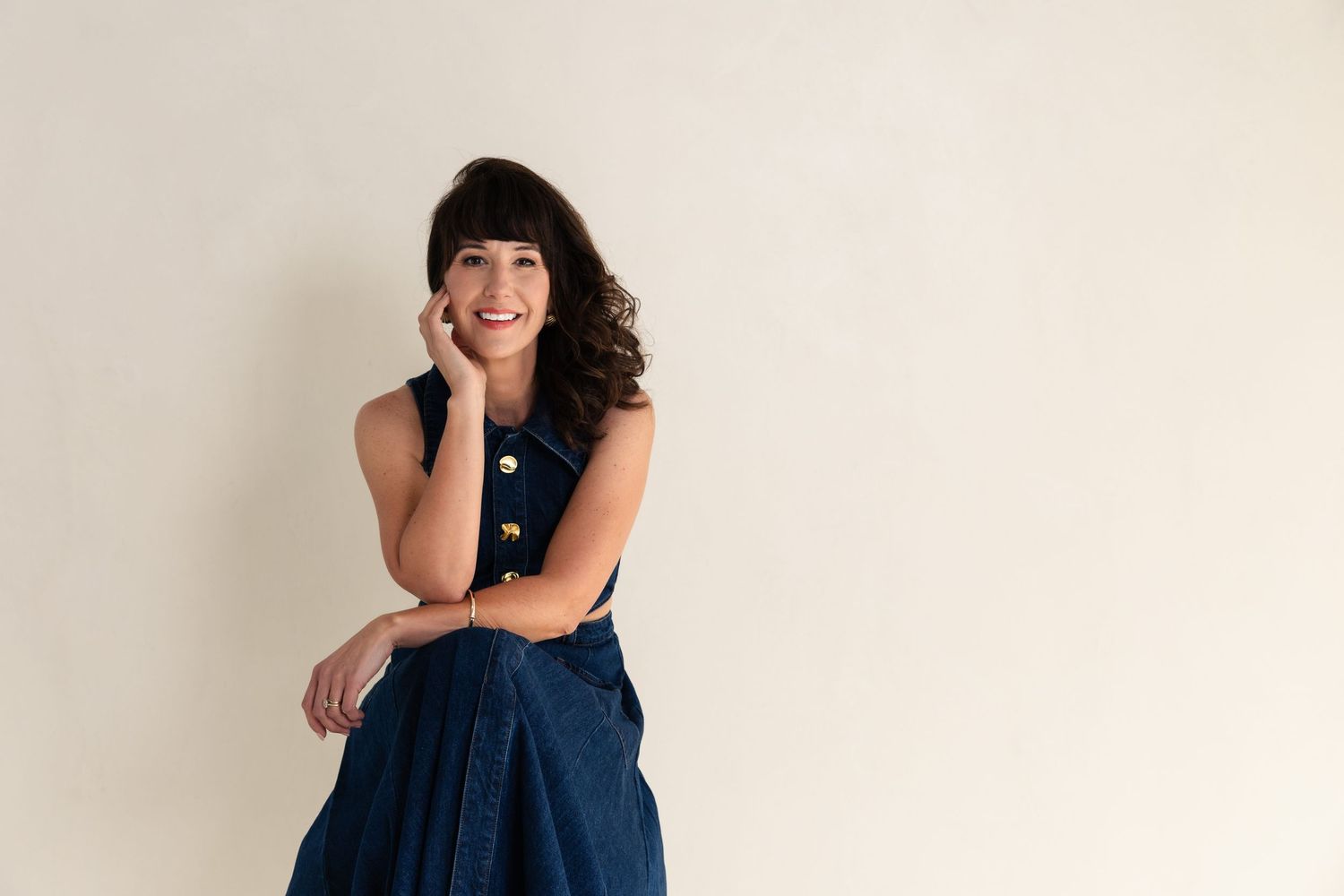 Studio portraits showing someone in navy dress against neutral background.