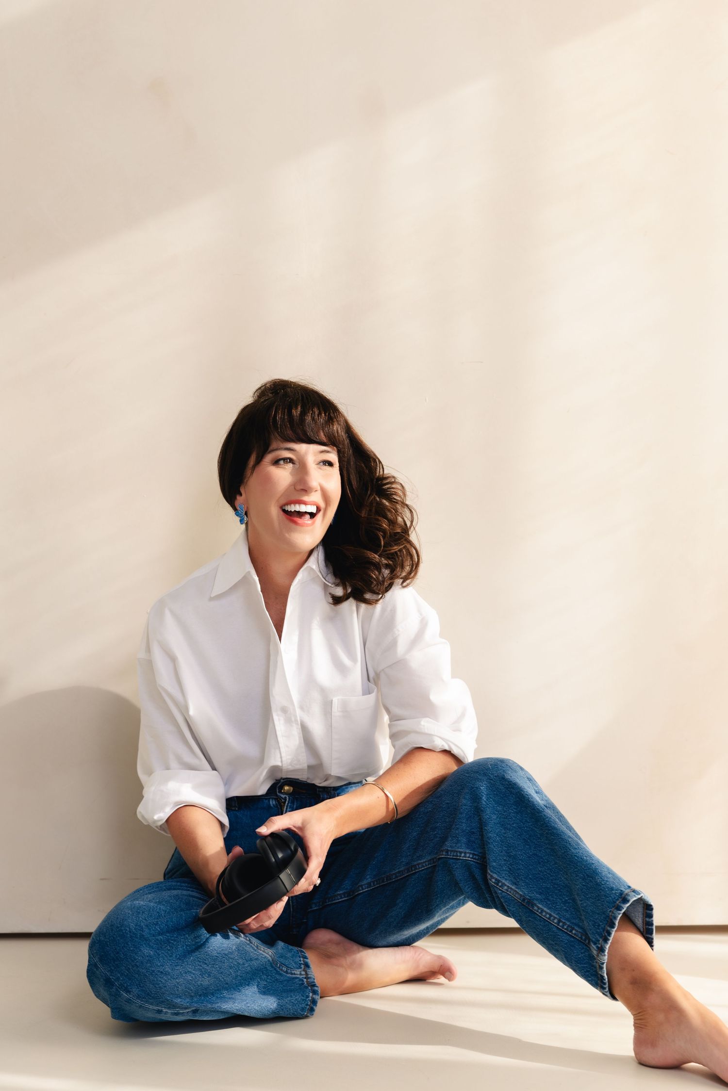 Casual portrait series in white shirt and jeans against light background.