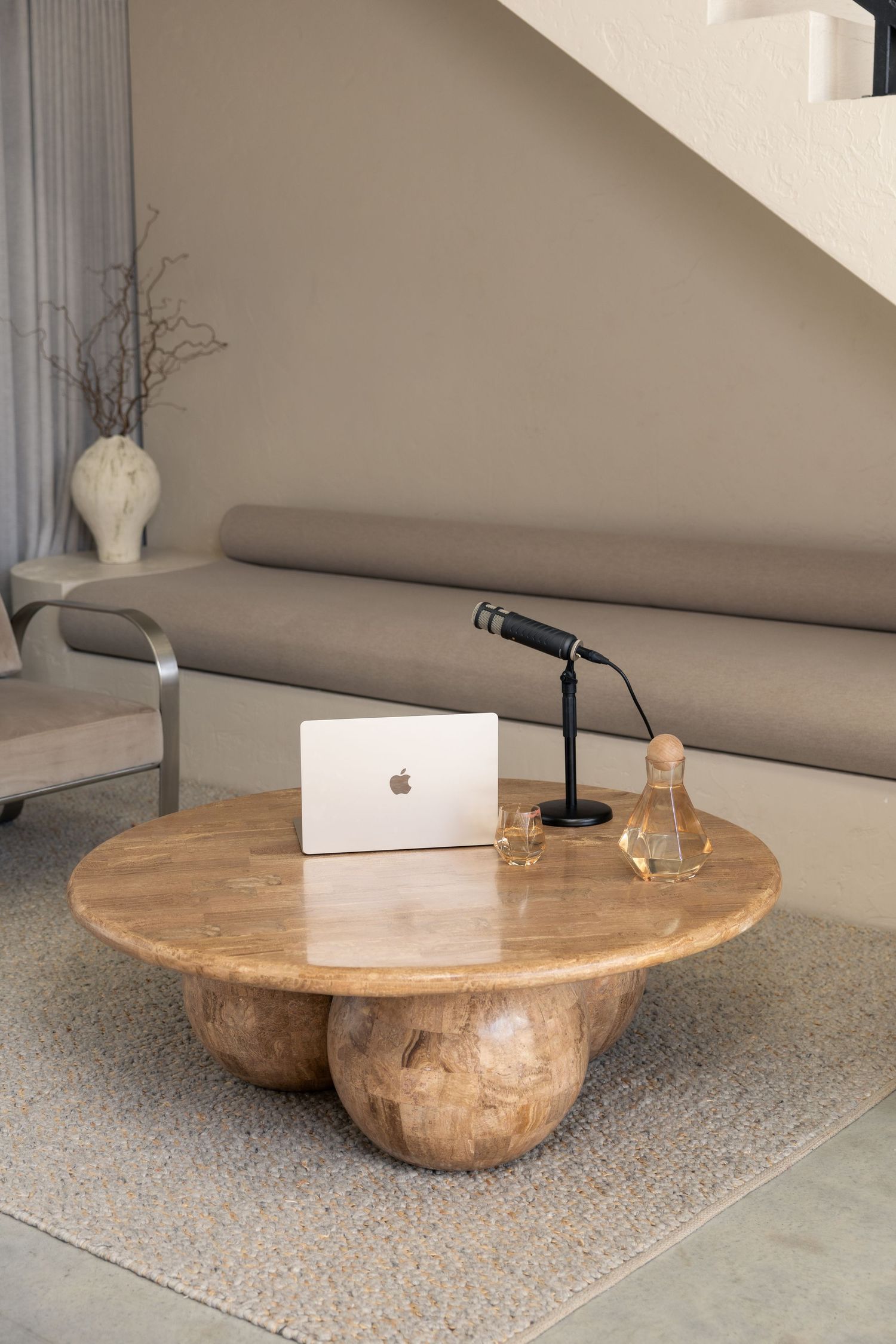 Modern stone coffee table with organic live edge design displayed on gray carpet with decorative items.