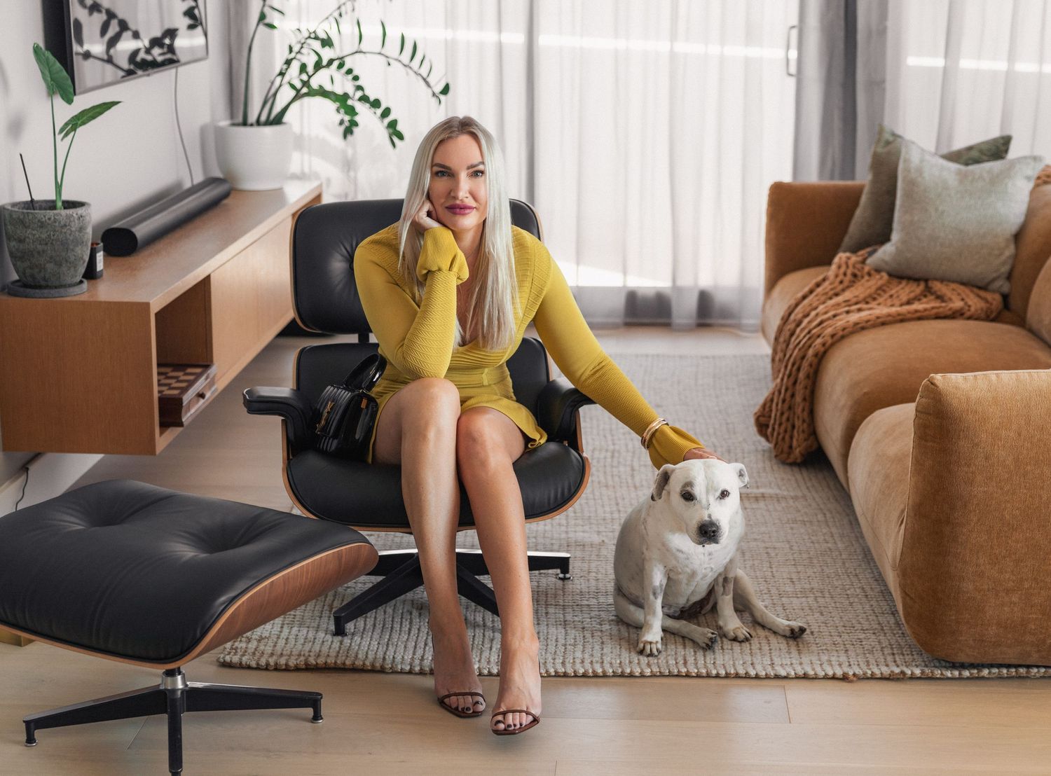 Lifestyle photos featuring a yellow-dressed person lounging with a white dog on modern furniture.